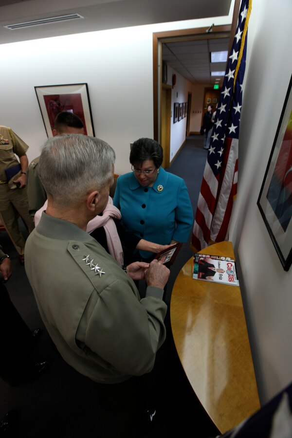 Gen. James F. Amos, 35th commandant of the Marine Corps, speaks with Rose M. Likins, ambassador of U.S. Embassy Lima and mother of a lance corporal currently serving with Fox Company, 2nd Battalion, 8th Marine Regiment about a photo of her son. Amos visited the embassy during his trip while attending the Marine Leaders of Americas Conference (MLAC) 2011. (U.S. Marine Corps photo by Lance Cpl. Angel Canosaldivias/Released)