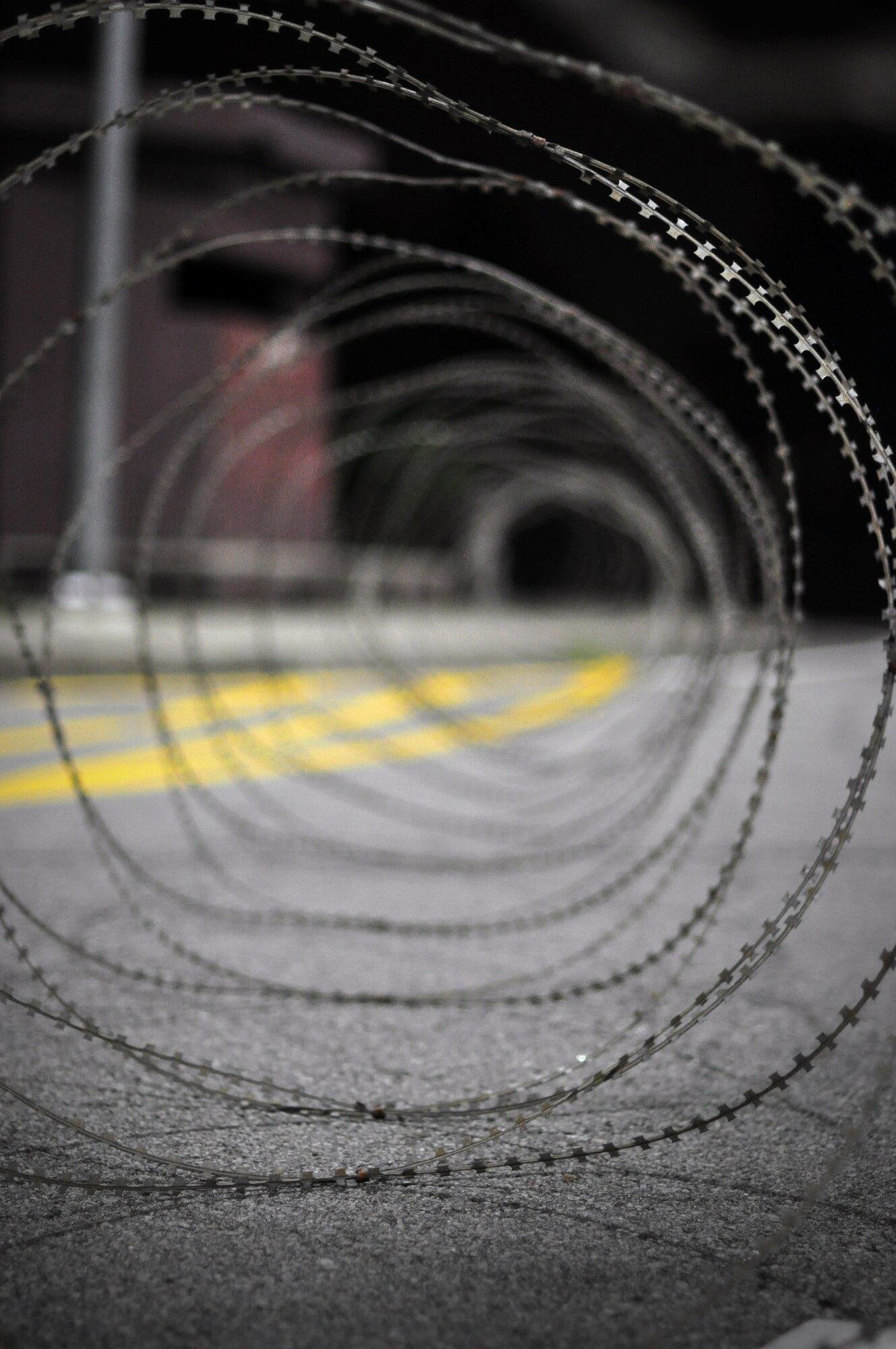 Concertina wire is placed around the base by members of the 51st Security Forces Squadron and base augmentees as the threat level heightens during exercise Beverly-Midnight 11-04. Exercises such as this test Osan's ability to survive and operate during a war-time constraint. (U.S. Air Force photo/Tech. Sgt. Chad Thompson)
