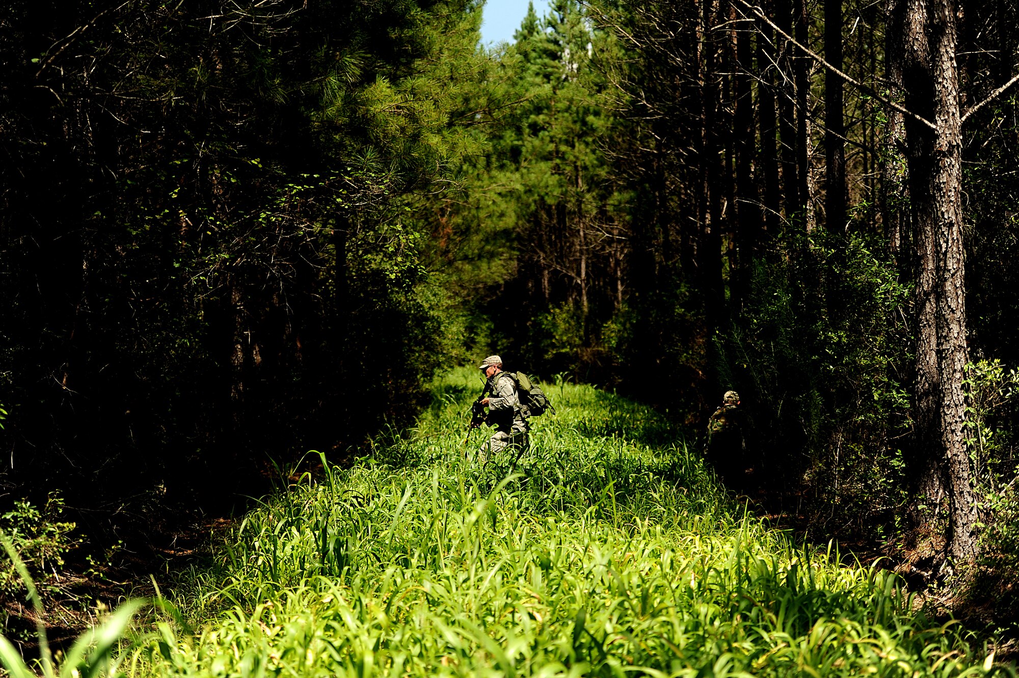Tactical Air Control Party (TACP)  A1C. Luke Nelson with the 284th Air Support Operations Squadron (ASOS), Boise, ID crosses an opening in the woods as his team navigates to their next point on August 15, 2011 at Townsend Range during a three day field exercise in Brunswick, GA. The exercise, is the final phase of their 45 day training class "Project 175", hosted by the 165th ASOS, where they will bring everything they have learned throughout the course and apply it to this scenario earning them their five level. During exercises, contingencies, or actual war, the Air Support Operations mission is to provide meteorological support and deploy with, advise, and assist the ground force commander in planning, requesting, coordinating and controlling close air support, tactical air reconnaissance, and tactical airlift.