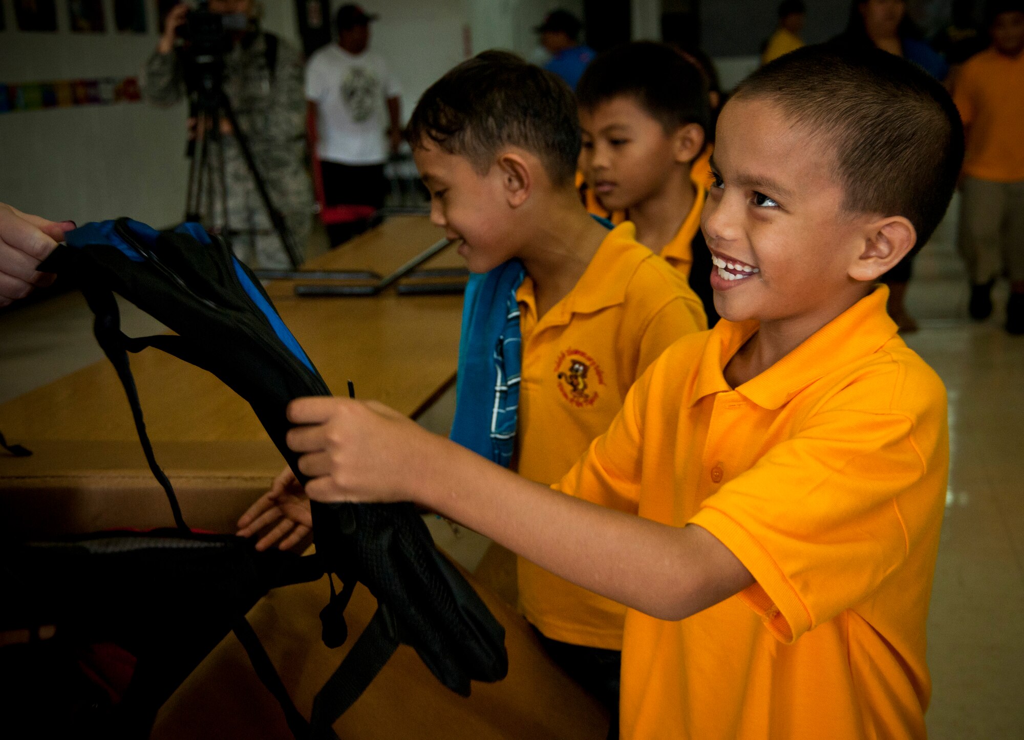 TALOFOFO, Guam—Juan Taijeron, third grade student at Talofofo Elementary School, receives a backpack from a member of  the 9th Operations Group Detachment 3 from Andersen Air Force Base Aug. 25. Airmen from the base gave approximately 150 backpacks to children that attend the elementary school. (U.S. Air Force photo by Senior Airman Benjamin Wiseman/Released)