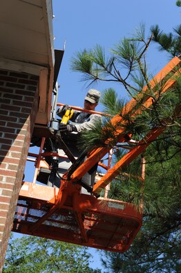 Staff Sgt. Adam Smith saws through a section of roof trim left hanging after an impact with a tree caused by the powerful winds of Hurricane Irene at Seymour Johnson Air Force Base, N.C., Aug. 28.  Smith and other members of the 4th CES worked to remove dangling debris from the roof over the Berkeley gate so it could reopen for vehicle and foot traffic.  Smith is from the 4th Civil Engineer Squadron Structures Shop and hails from Cortland, N.Y. (U.S. Air Force photo by 1st Lt. Matt Schroff/Released)