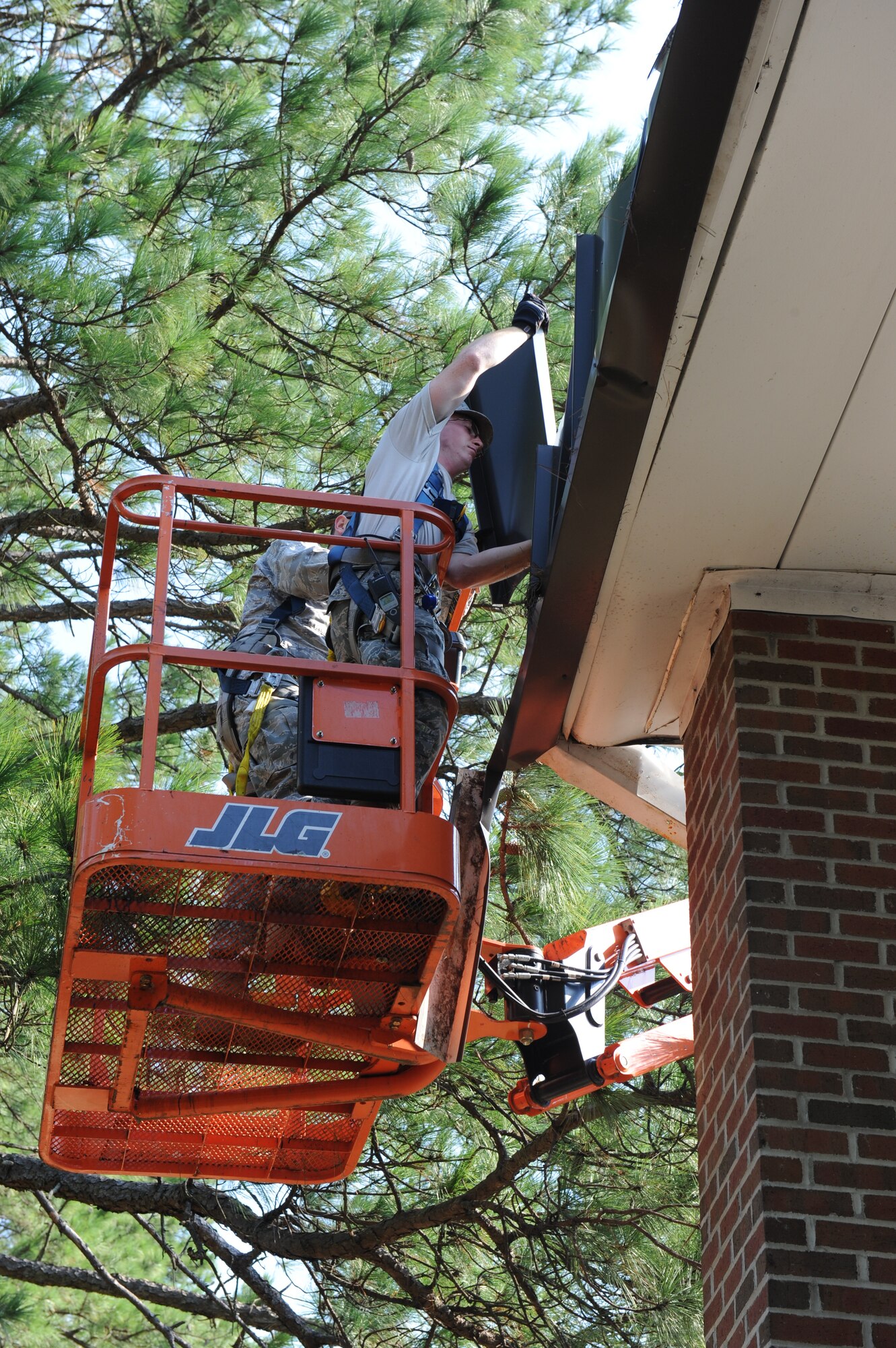 Airman 1st Class Calvin Myers removes a large piece of siding from the Berkeley gate guard shack roof in the aftermath of Hurricane Irene at Seymour Johnson Air Force Base, N.C., Aug. 28.  The base received nearly ten inches of rainfall and 60-knot winds Saturday which resulted in approximately 40 fallen trees and roof damage to a few base facilities.  Myers is from the 4th Civil Engineer Squadron Structures Shop and hails from Canton, N.C. (U.S. Air Force photo by 1st Lt. Matt Schroff/Released)