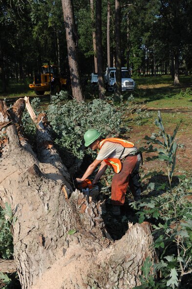 Senior Airman Jacob Russell saws through the trunk of a tree that fell near Heritage Hall during high winds brought on by Hurricane Irene at Seymour Johnson Air Force Base, N.C., Aug. 28.  Civil Engineer work crews arrived before dawn to begin the monumental task of clearing nearly 40 fallen trees and limbs from areas across the base.  Russell,4th Civil Engineer Squadron heavy equipment operator, hails from Malvern, Ark.  (U.S. Air Force photo by 1st Lt. Matt Schroff/Released)