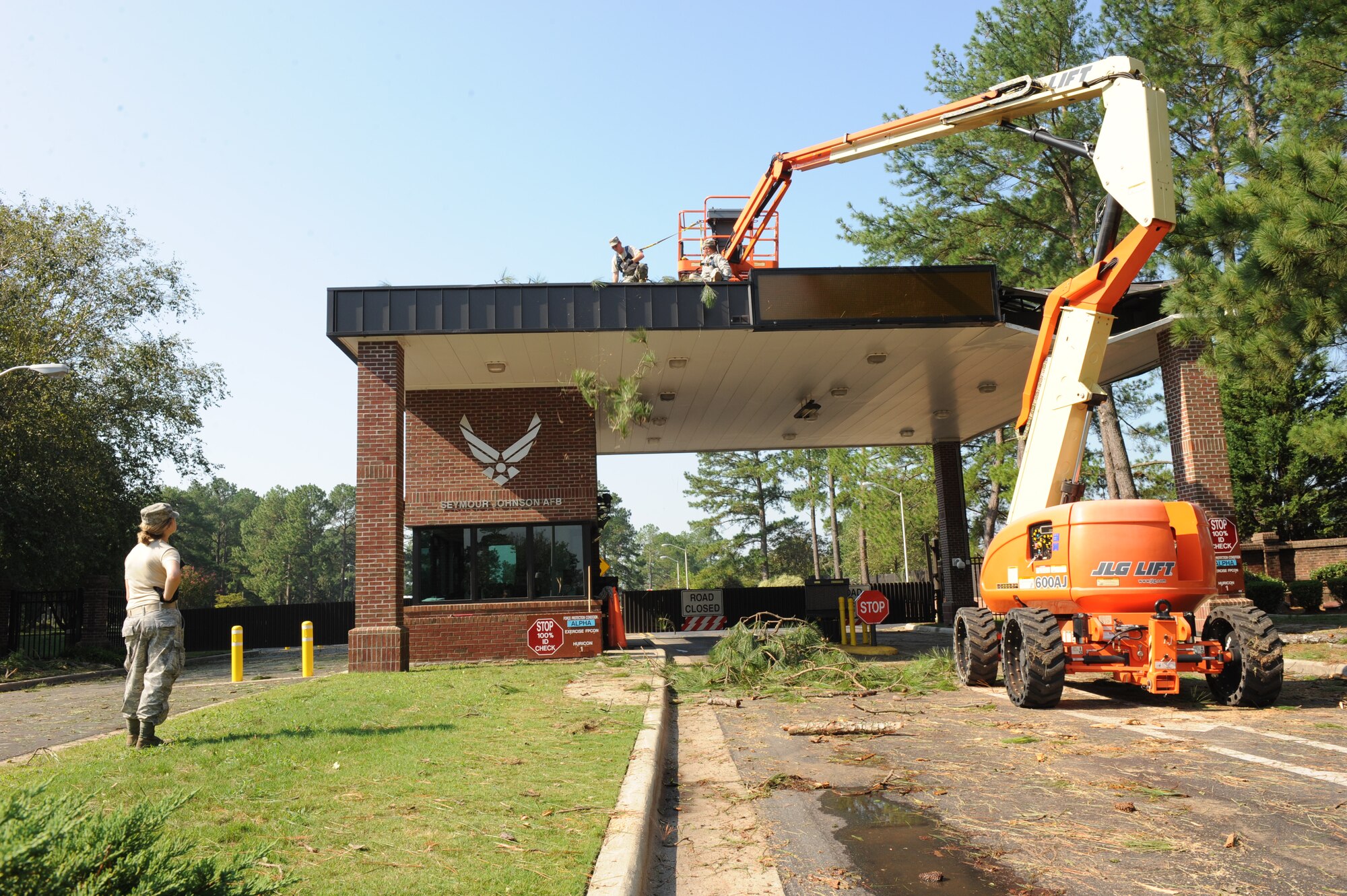 Staff Sgt. Adam Smith and Airman 1st Class Calvin Myers remove branches from atop the Berkeley gate guard shack while Senior Airman Keny Brown looks on at Seymour Johnson Air Force Base, N.C., Aug. 28.  The majority of base services were closed Saturday in preparation for Hurricane Irene’s projected destructive path up the Carolina coast.  Smith is from Cortland, N.Y., Myers is from Canton, N.C. and Brown is from Savannah, Ga.  All are from 4th Civil Engineer Squadron Structures Shop.  (U.S. Air Force photo by 1st Lt. Matt Schroff/Released)