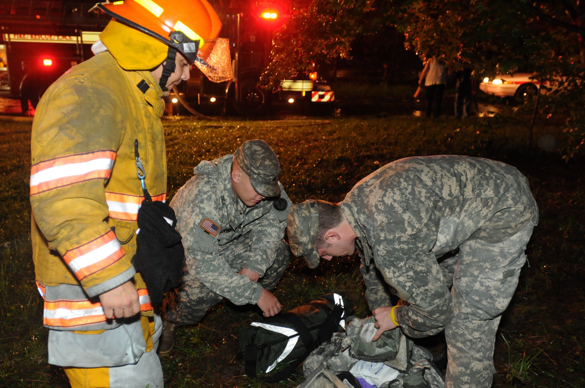 Army Sgt. Matt Ryan and Army Staff Sgt. Will Phillips, both medics from the 224th Area Support Medical Company of the Maryland National Guard, assist local firefighters as they exit a house fire in Salisbury, Md., Aug. 27, 2011. Local first responders were called to a house fire after a tree downed by Hurricane Irene caused power lines to arc electricity through a surge protector inside the home. Residents were home and were able to exit the house to safety. (U.S. Army photo/Sgt. Darron Salzer)