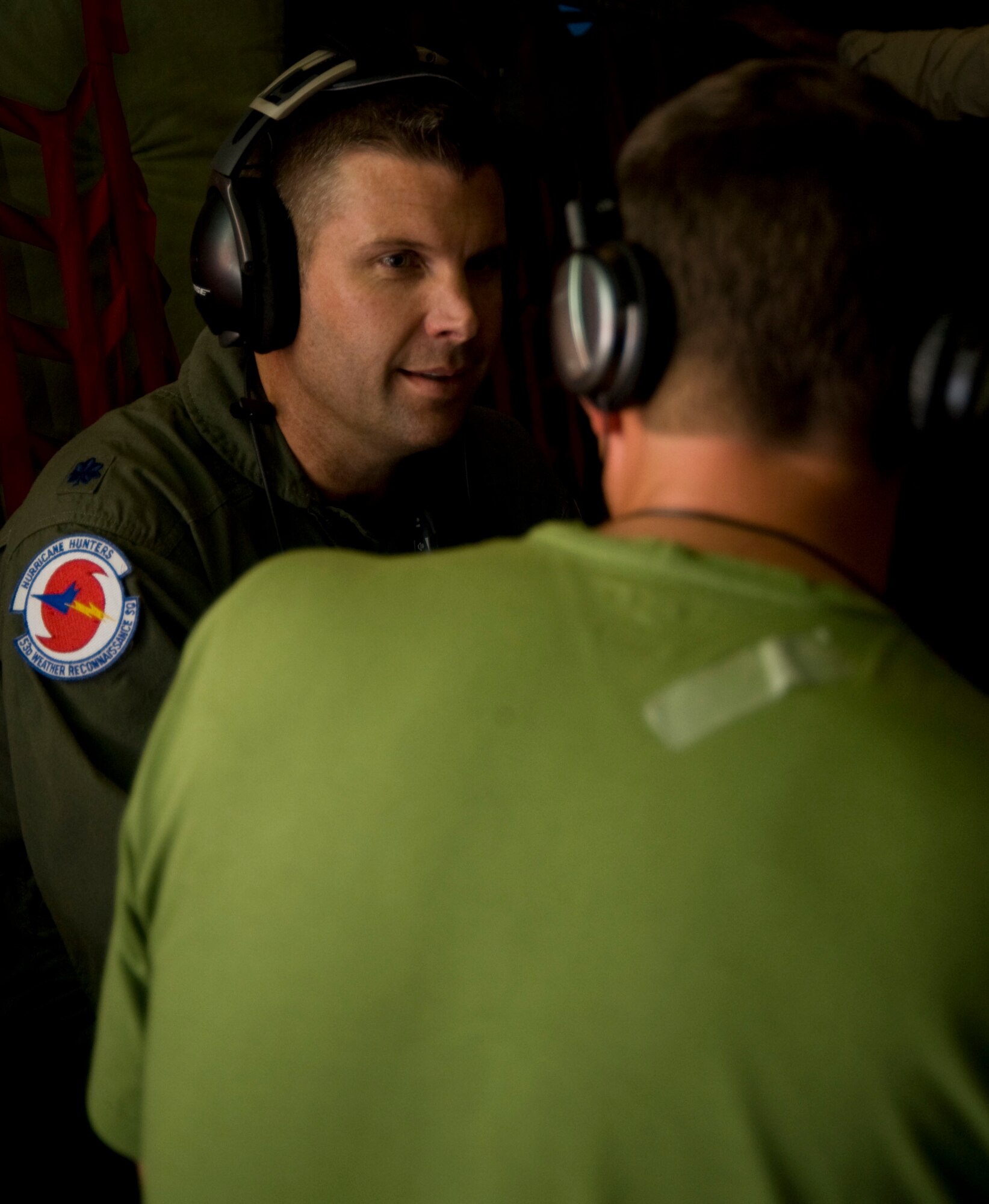 Lt. Col. Sean Pierce, 53rd Weather Reconnaissance Squadron director of operations, takes a moment to speak with Andy McDonald while on a mission into the eye of Hurricane Irene Aug. McDonald and other members of the media were afforded the opportunity to fly with the Hurricane Hunters during the Aug. 25 reconnaissance mission.