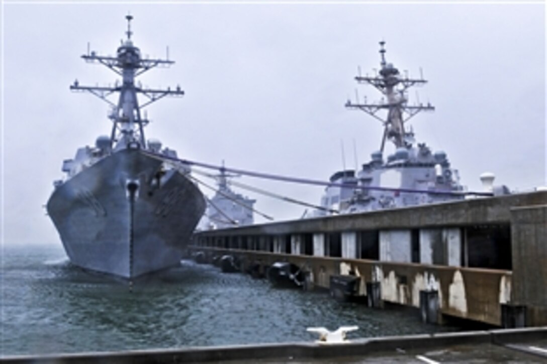The guided missile destroyers USS Ross, USS Forrest Sherman, the amphibious dock landing ship USS Fort McHenry and the guided-missile cruiser USS Normandy sit safely at Naval Station Norfolk, Norfolk, Va., Aug. 27, 2011, as Hurricane Irene passes over the area. Irene made landfall near Cape Lookout, N.C., with sustained winds of 85 mph.