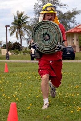 Master Sgt. Doug Downing, 36th Wing Staff Agency 1st Sgt., carries a fire hose during the physical challenge portion of Andersen’s version of Fear Factor. More than 20 competitors participated in Andersen’s Annual Fear Factor challenge for a grand prize of two $200 Delta Airlines travel vouchers. In the end, Jacob Greathouse, a Team Andersen dependant, was able to clench victory and the grand prize. (U.S. Air Force photo /Airman Basic Anthony Jennings) 

