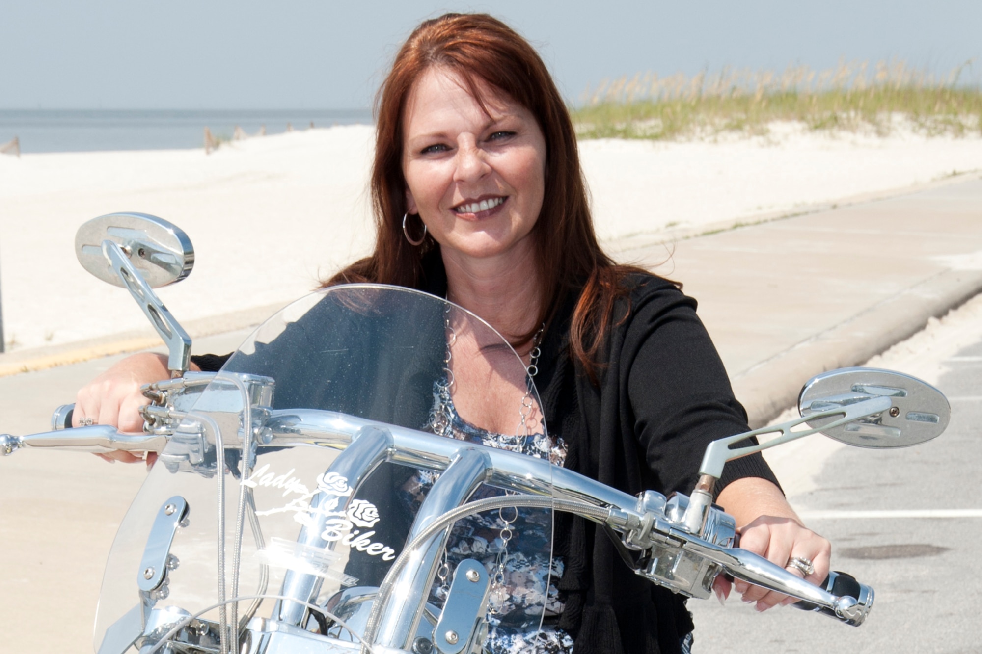 Chantel Jensen, wife of 403rd Wing commander Col. Jay Jensen, poses on her motorcycle along the beach outside the main gate of Keesler Air Force Base, Miss. Mrs. Jensen and the colonel returned to the Gulf Coast in May 2011 after three years. The two lived here previously while the commander served in other positions for the 403rd WG. (U.S. Air Force photo/Tech. Sgt. Ryan Labadens)