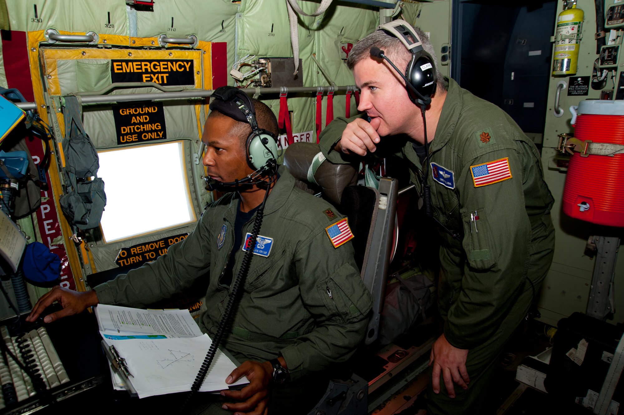 Majs. Kevin Fryar, aerial reconnaissance weather officer, and Andrew Clark, navigator, discuss alternative flight paths through Hurricane Irene, which had just made landfall over the North Carolina coast August 27. Navigators and ARWOs for the 53rd Weather Reconnaissance Squadron coordinate during hurricane flights to balance data collection with aircraft safety. Certain areas that look good for gathering storm data may be ripe for water spouts or other unfavorable weather conditions. (U.S. Air Force photo/Tech. Sgt. Ryan Labadens))