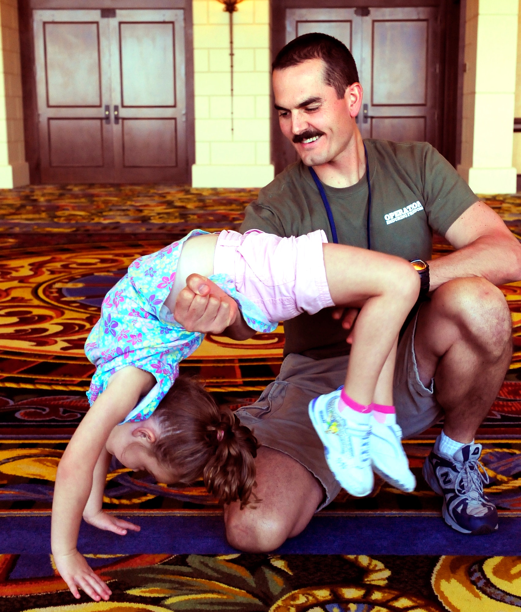 Navy Aircraft Structural Mechanic First Class Charles Peterman gives four-year-old daughter Alyssa a boost in her back handspring during a Yellow Ribbon Reintegration event at a Dallas-area hotel August 27. Peterman returned to NAS Fort Worth JRB, Texas, a few days ago from a year-long deployment to Afghanistan and attended the event with his wife Wendy and their children Aiden, Alyssa and Austin. The Yellow Ribbon Reintegration Program was initiated by Congress in 2008, and offers access to information, resources, and benefits to National Guard and Reserve servicemembers and their families before, during, and after deployments.  (U.S. Air Force photo/Senior Airman Martha Whipple)