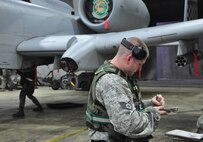Staff Sgt. Wesley Daniel, 51st Maintenance Group, checks some paperwork while an Airman gets an A-10 Thunderbolt II assigned to the 25th Fighter Squadron ready for munitions August 29, 2011, during an Operation Readiness Exercise. Exercises such as this test Osan's ability to survive and operate during a war-time constraint. (U.S. Air Force photo/Tech. Sgt. Chad Thompson)