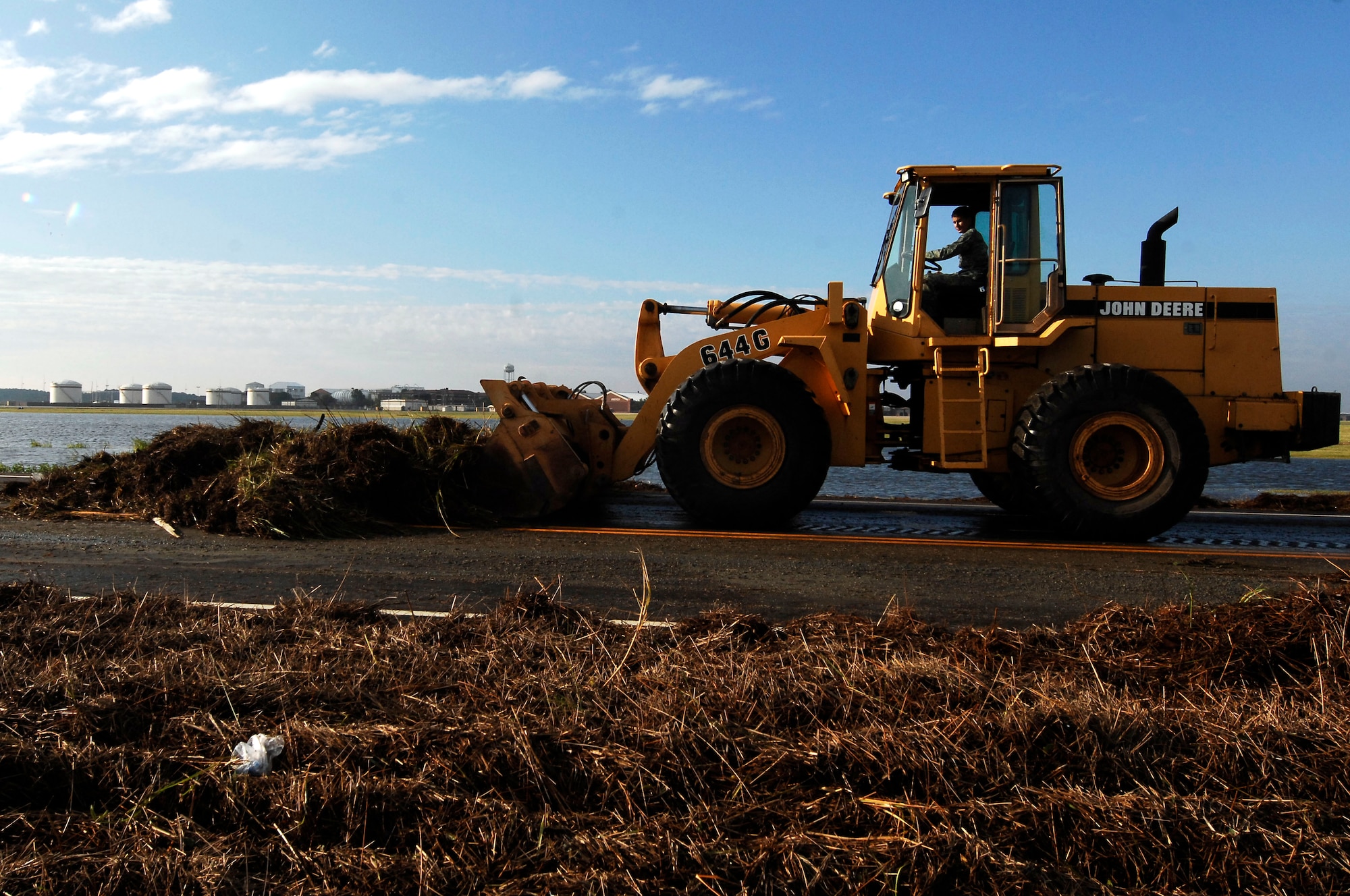 An Airman from the 633rd Civil Engineer Squadron removes debris on Ward Road washed up during flooding caused by Hurricane Irene at Langley Air Force Base, Va., Aug. 28, 2011. Langley AFB experienced approximately 8.8 inches of rain and an estimated 7.5 foot storm surge during the hurricane.  . (U.S. Air Force photo by Airman 1st Class Kayla Newman/Released)