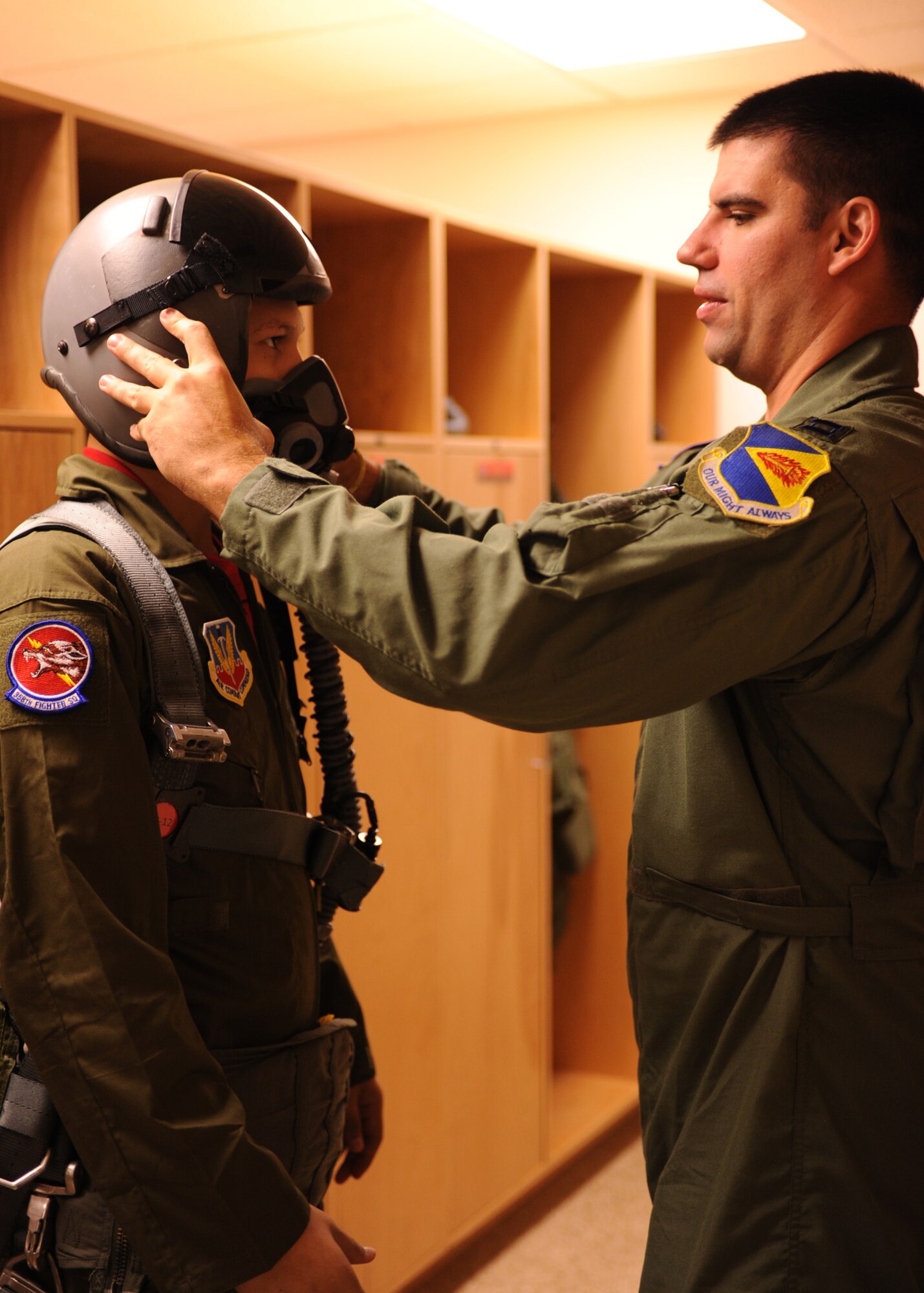 DAVIS-MONTHAN AIR FORCE BASE, Ariz. – Capt. Jason Pruitt, 358th Fighter Squadron, fits his helmet on Brandon Valles here Aug. 26. (U.S. Air Force photo/Airman 1st Class Christine Halan)