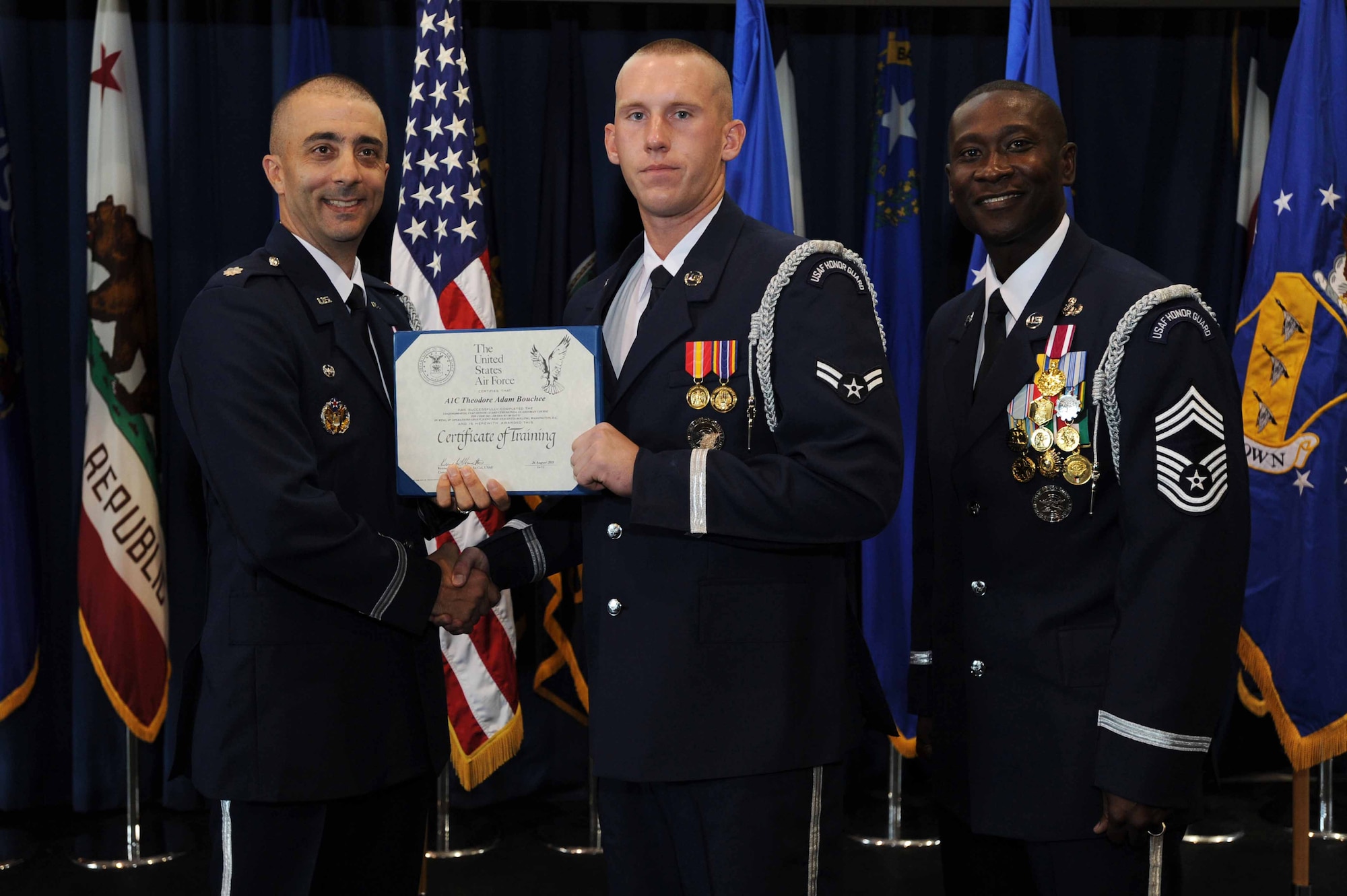 Lt. Col. Kenneth A. Marentette, U.S. Air Force Honor Guard commander, presents Airman 1st Class Theodore A. Bouchee, USAF Honor Guard ceremonial guardsman, with a certificate for completing technical training school Aug. 26 on Joint Base Anacostia-Bolling, Washington D.C. After completing the eight week training course, the new graduates will have to fulfill the USAF Honor Guard's mission at Arlington National Cemetery, Va. (U.S. Air Force photo by Staff Sgt. Christopher Ruano)