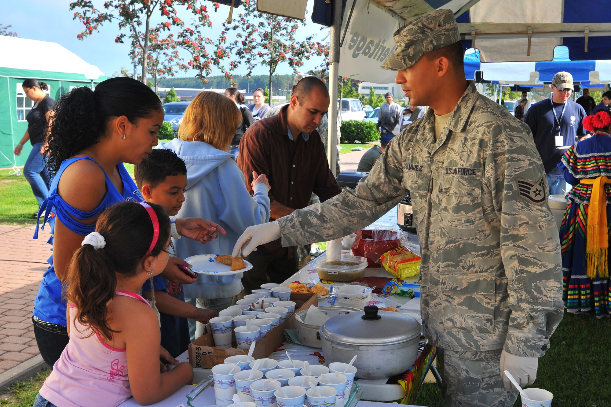 SPANGDAHLEM AIR BASE, Germany – Staff Sgt. Joseph Suarez, 52nd Medical Operations Squadron, passes out food samples at the Hispanic heritage booth during Diversity Day festivities outside Club Eifel here Aug. 25. Diversity Day showcased numerous attractions and booths displaying cultural and ethnic diversity among Air Force service members and their families. (U.S. Air Force photo/Airman 1st Class Dillon Davis)
