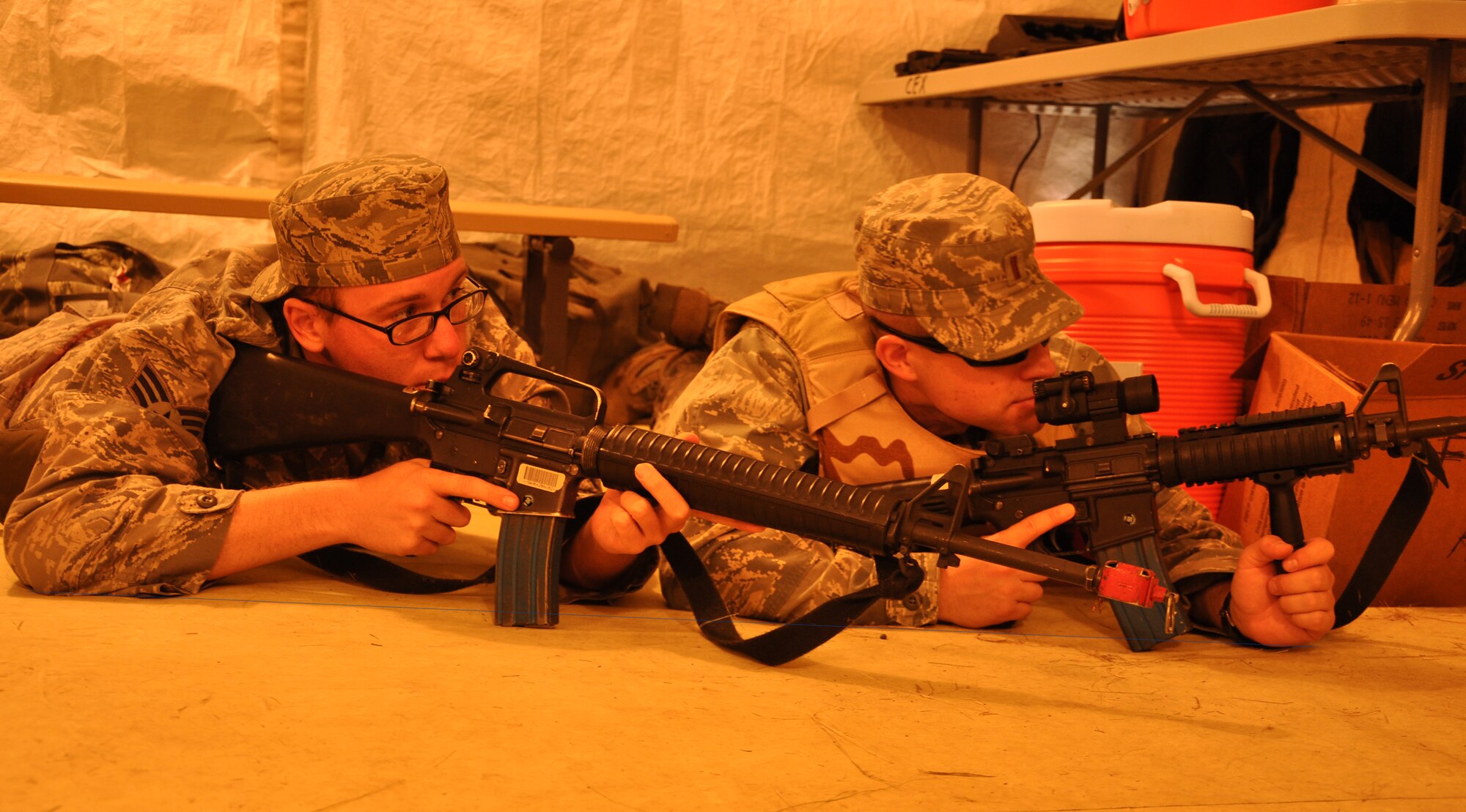 Senior Airman Jason Brown, a public affairs staff writer from the 633rd
Air Base Wing at Joint Base Langley Eustis, and 2nd Lt. Mark Flannery, a
public affairs officer from "The Chief's Own" 11th Wing at Joint Base
Andrews, take cover and guard a door during a simulated attack during
"Operation EAGLE FLAG." The exercise is designed to provide U.S. forces with
an environment to test the knowledge and skills required for any type of
forward operation, in any condition, regardless of mission or aircraft type.
The tandem made up the 421st Air Expeditionary Group public affairs team and
provided a full complement of public affairs products in support of the
exercise, earning recognition and praise from their leadership and the staff
from Joint Base McGuire-Dix-Lakehurst's Expeditionary Operations Center
cadre and evaluation team. (U.S. Air Force photo/Senior Airman Jason Brown)
 