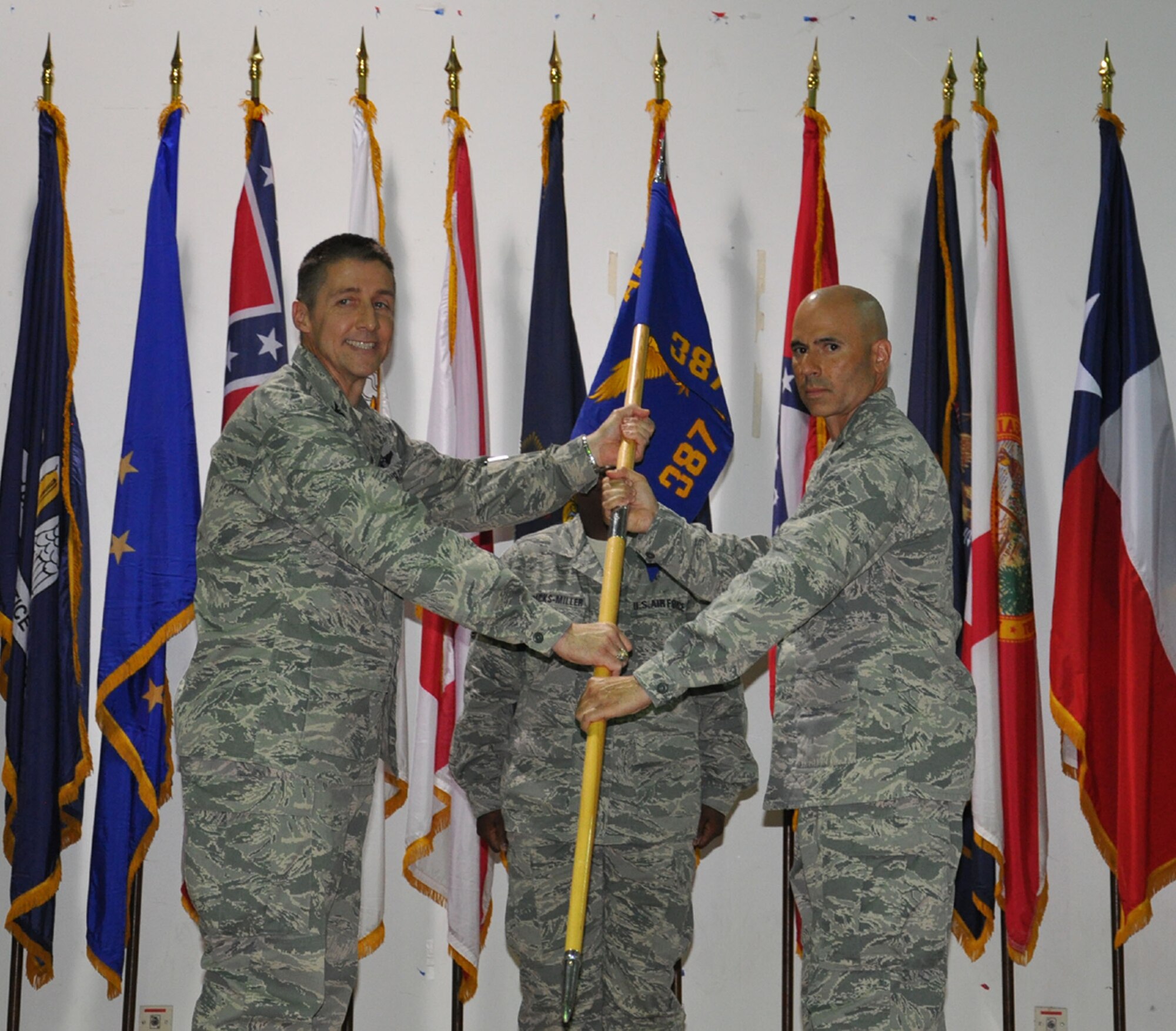Col Scott DeThomas, left, passes the reigns of command of the 387th Expeditionary Logistics Readiness Squadron to Lt Col John P. O'Connor during a change of command ceremony August 27 at an undisclosed location in Southwest Asia.  Lt Col O'Connor assumed command of the 387th ELRS from Lt Col Christopher A. Boone (U.S. Air Force photo by Capt Greta Lewis