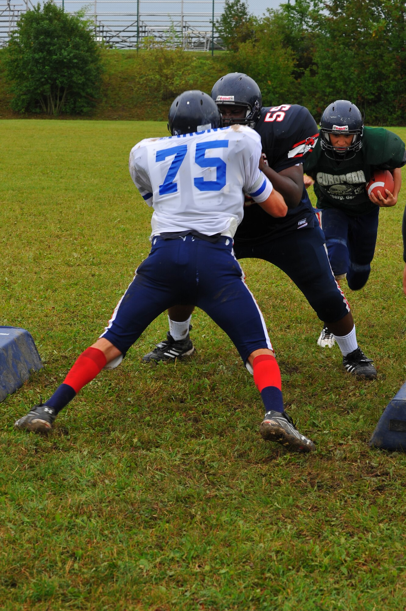 BITBURG ANNEX, Germany – Bitburg High School football players run offensive and defensive blocking drills during football practice here Aug. 24. The football team practices five days each week. Practices normally consist of a warm-up, cardio, strengthening exercises, hitting drills, blocking drills and running drills. The season tentatively kicks off with an away game against Heidleberg on Sep. 3. (U.S Air Force photo/Airman 1st Class Dillon Davis)