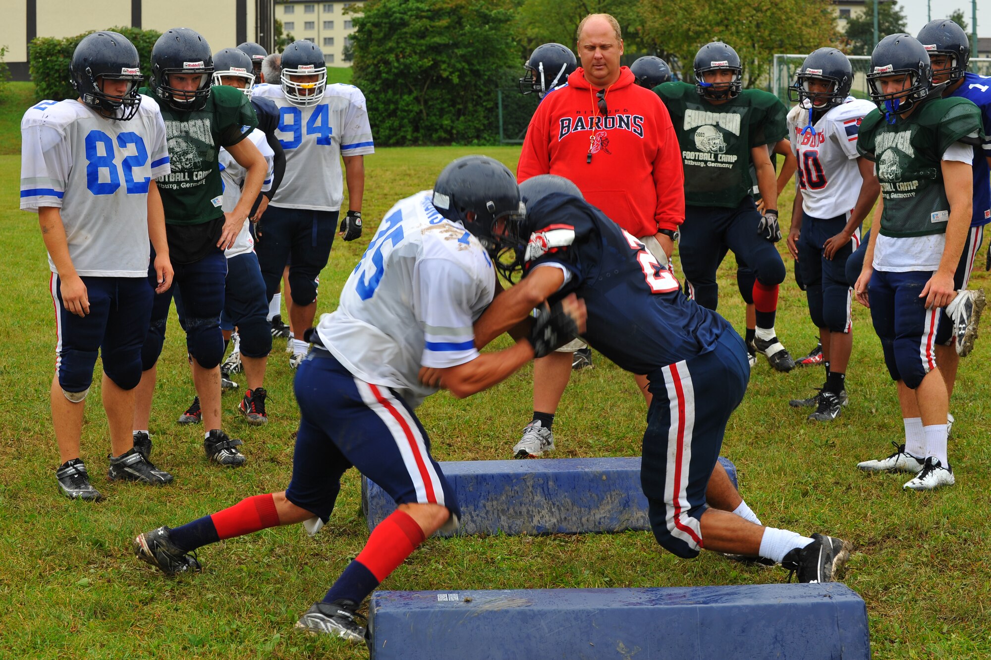 BITBURG ANNEX, Germany – Bitburg High School football players run offensive and defensive blocking drills during football practice here Aug. 24. The football team practices five days each week. Practices normally consist of a warm-up, cardio, strengthening exercises, hitting drills, blocking drills and running drills. The season tentatively kicks off with an away game against Heidleberg on Sept. 3. (U.S Air Force photo/Airman 1st Class Dillon Davis)
