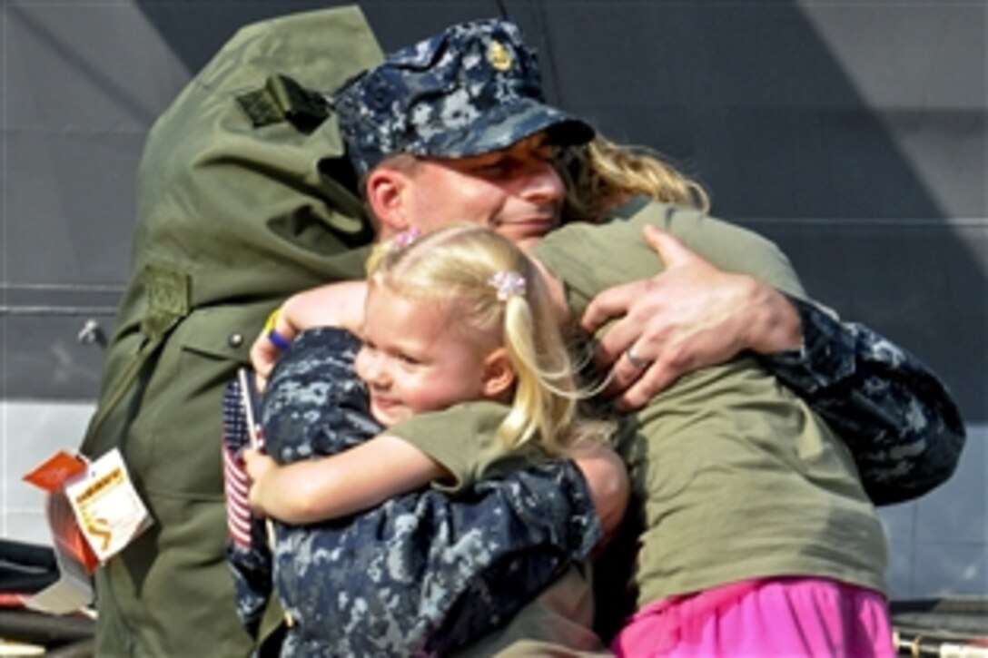 U.S. Navy Chief Petty Officer Marc De St. Aubin hugs his daughters after the U.S. 7th Fleet command ship USS Blue Ridge arrives at Commander, Fleet Activities Yokosuka, Japan, Aug. 29, 2011. The Blue Ridge returned to Yokosuka after a two-month patrol throughout the Pacific region. De St. Aubin is an intelligence specialist.