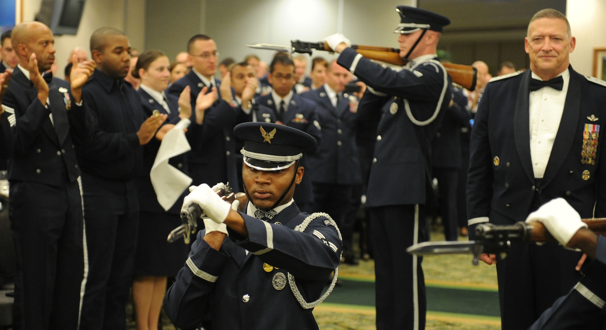 General Gary North, Pacific Air Forces commander, stands at attention as the U.S. Air Force Honor Guard Drill Team gives a special performance commemorating the night, during the Order of the Sword ceremony at the Tradewinds enlisted club at Joint Base Pearl Harbor-Hickam, Hawaii, Aug. 26. General North is the 17th PACAF member to receive the prestigious Order of the Sword.  The ceremony is conducted by noncommissioned officers to honor leaders who have made significant contributions to the enlisted corps. This ceremony reflects the highest recognition the enlisted corps can bestow on anyone. (U.S. Air Force photo/Tech. Sgt Jerome S. Tayborn) 