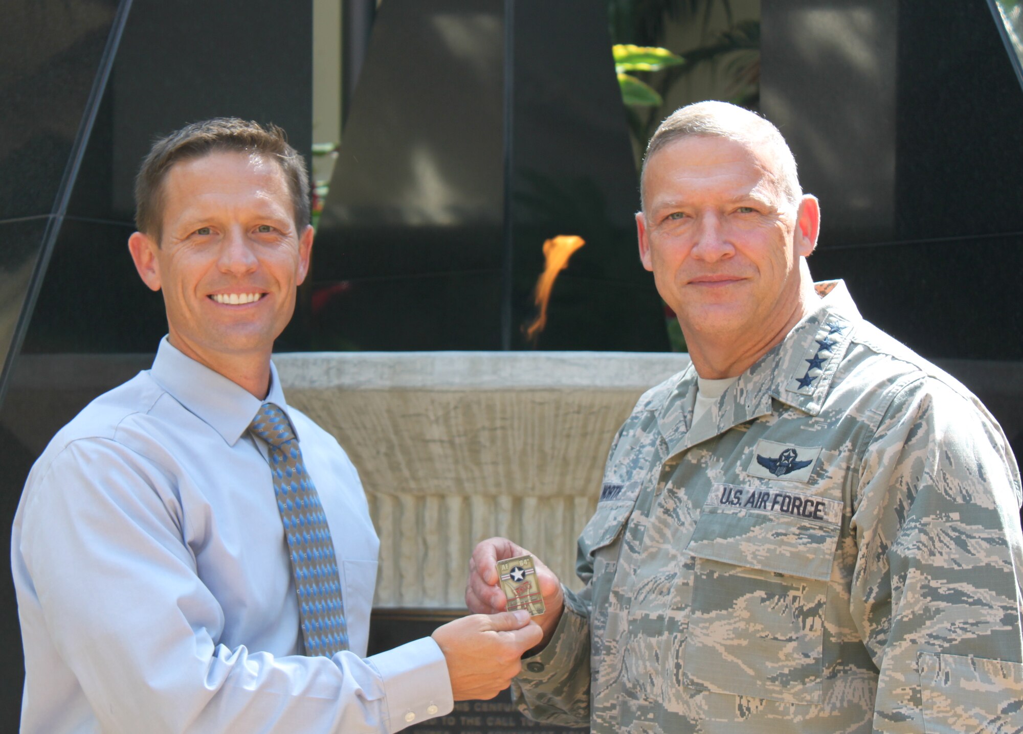 Gen. Gary North, Pacific Air Forces commander, (right) purchases an Air Force Ball ticket, numbered 0001, from Birthday Ball Committee President Greg Green (left) in the Courtyard of Heroes on Joint Base Pearl Harbor-Hickam, Hawaii, Aug 29.  The 64th Air Force Ball will be held Sep 16th at the Hilton Hawaiian Village. (U.S, Air Force photo/Sol Green)