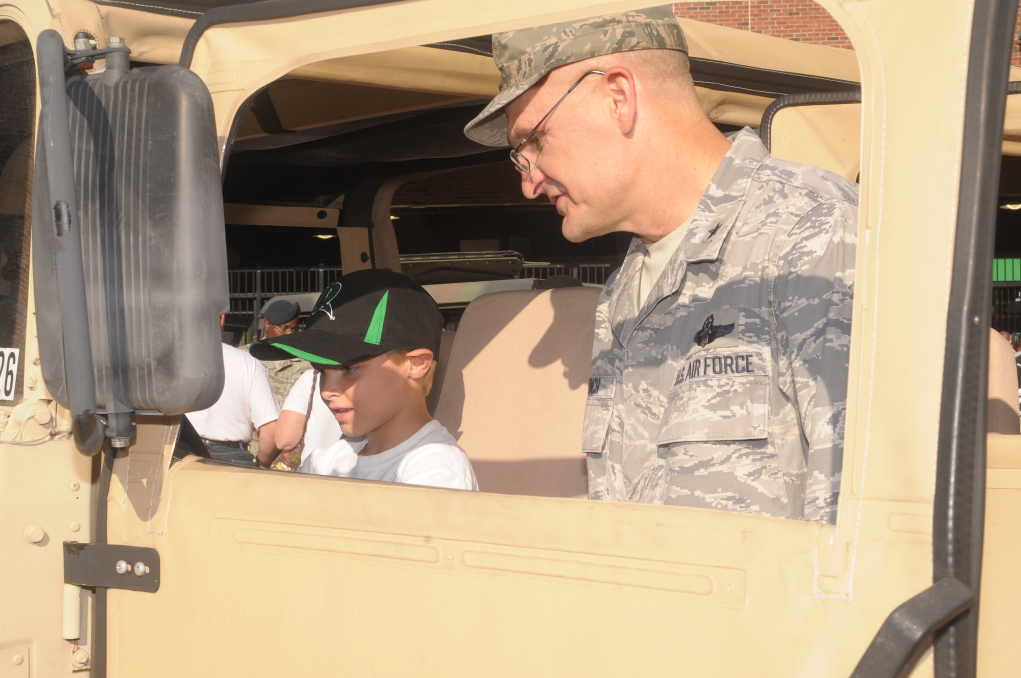 Brig. General Arnold Bunch, Air Force Security Assistance Command commander, explores a static display of a military humvee with a Dayton Dragons fan.  The Dayton Dragons partnered with the Dayton Development Coalition to host “Hometown Heroes Celebration Night,” on Saturday, Aug. 27. The event pays tribute to the local servicemen and women of Wright-Patterson Air Force Base and the Springfield Air National Guard (U.S. Air Force photo/ Albert Bright)