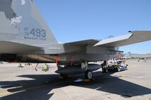 Senior Airman Andrew Petersen prepares to hook up and move an F-15 Eagle with an electrical tug made by the Ore. based company Lektric as Tech. Sgt. Eric Harris guides him in July 24, 2011 at Kingsley Field, Klamath Falls, Ore.  The 173rd Fighter Wing is testing out the newly designed electrical tug that is much more maneuverable and efficient compared to the traditional diesel tug.  All of the Airmen are from the 173rd Fighter Wing Inspection Element.   (U.S. Air Force Photo by Tech. Sgt. Jennifer Shirar) RELEASED