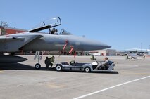 Senior Airman Andrew Petersen prepares to hook up and move an F-15 Eagle with an electrical tug made by the Ore. based company Lektric as Tech. Sgt. Eric Harris guides him in and Master Sgt. Jeff Johnson sits in the cockpit July 24, 2011 at Kingsley Field, Klamath Falls, Ore.  The 173rd Fighter Wing is testing out the newly designed electrical tug that is much more maneuverable and efficient compared to the traditional diesel tug.  All of the Airmen are from the 173rd Fighter Wing Inspection Element.   (U.S. Air Force Photo by Tech. Sgt. Jennifer Shirar) RELEASED