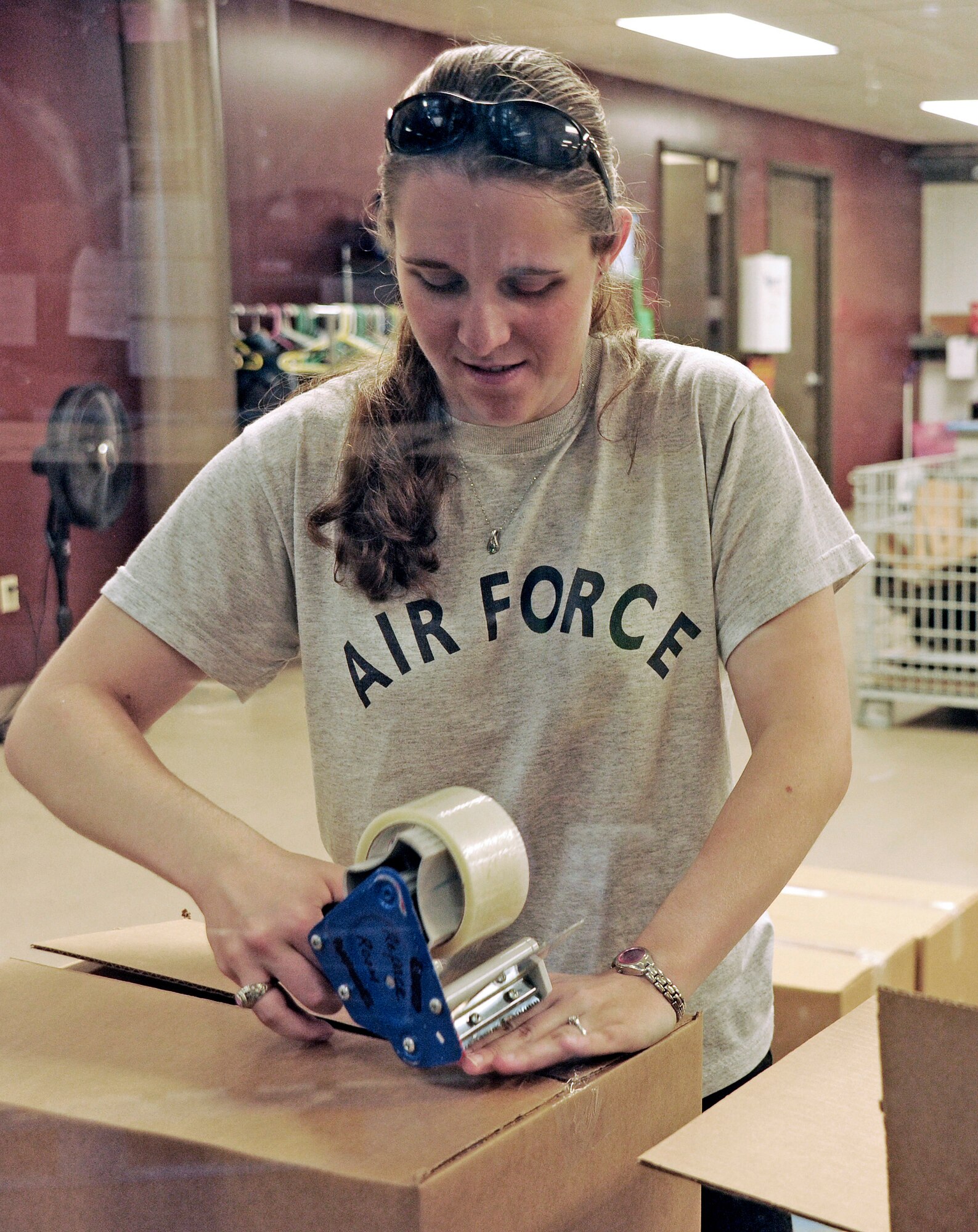 Cadet 1st Class Philicia Fahrenbruch tapes up a box of foodstuffs during a Cadet Interfaith Council volunteer effort at the Care and Share Food Bank in Colorado Springs, Colo., Aug. 27, 2011. The Air Force Academy entered the volunteer partnership with Care and Share as part of the White House's Interfaith and Community Service Campus Challenge and looks to expand the scope of its interfaith outreach in future years. Fahrenbruch, the Cadet Interfaith Council president, is assigned to Cadet Squadron 12. (U.S. Air Force photo/Sarah Chambers)