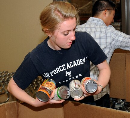 Cadet 3rd Class Tirzah Prince gathers canned goods to make a box of food at the Care and Share Food Bank of Southern Colorado Aug. 27, 2011. Care and Share was founded approximately 35 years ago and distributed approximately 18.5 million pounds of food throughout Southern Colorado in its 2010 fiscal year. Prince is assigned to Cadet Squadron 29. (U.S. Air Force photo/Sarah Chambers)