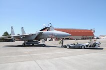 Senior Airman Andrew Petersen prepares to hook up and move an F-15 Eagle with an electrical tug made by the Ore. based company Lektric as Tech. Sgt. Eric Harris guides him in and Master Sgt. Jeff Johnson sits in the cockpit July 24, 2011 at Kingsley Field, Klamath Falls, Ore.  The 173rd Fighter Wing is testing out the newly designed electrical tug that is much more maneuverable and efficient compared to the traditional diesel tug.  All of the Airmen are from the 173rd Fighter Wing Inspection Element.   (U.S. Air Force Photo by Tech. Sgt. Jennifer Shirar) RELEASED