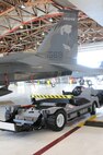 An electrical tug made by the Ore. based company Lektric  sits in the hangar next to a 173rd Fighter Wing F-15 Eagle, Oregon Air National Guard, July 24, 2011 at Kingsley Field, Klamath Falls, Ore.  The 173rd Fighter Wing is testing out the newly designed electrical tug that is much more maneuverable and efficient compared to the traditional diesel tug.  (U.S. Air Force Photo by Tech. Sgt. Jennifer Shirar) RELEASED