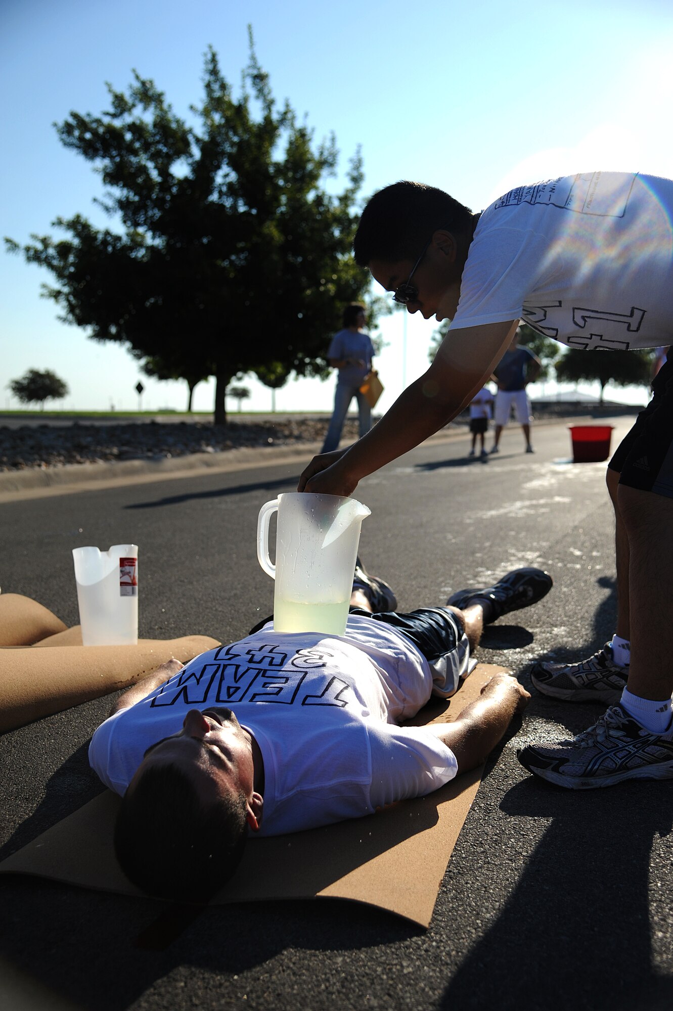 GOODFELLOW AIR FORCE BASE, Texas -- Airmen 1st Class Michael Leon and Daniel Hoang, 315th Training Squadron students, use teamwork to complete a challenge to fill up a pitcher of water using sponges Aug. 27. After completing each challenge a clue is revealed guiding the teams to the next challenge of the Remarkable Race. (U.S. Air Force photo/Airman 1st Class Michael Smith)