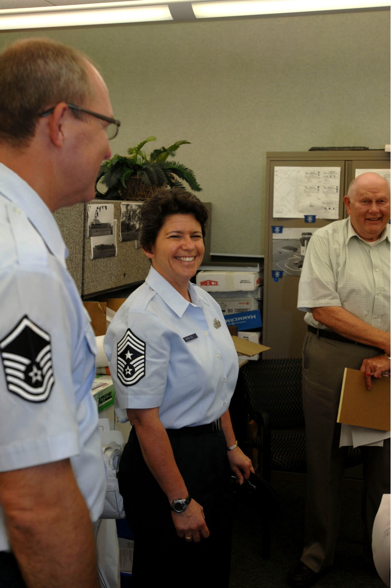 GRISSOM AIR RESERVE BASE, Ind. -- Chief Master Sgt. Karen Perkins shares a funny moment with  the 434th Civil Engineer Squadron staff Aug. 8. Perkins officially took her position as the 434th Air Refueling Wing command chief Aug 1. Pictured from left to right is Master Sgt. Christopher Rust, 434th CES unit training manager, and Mr. Lee Stonestreet, 434th CES civil engineer . (U.S. Air Force photo/Senior Airman Jami K. Lancette)