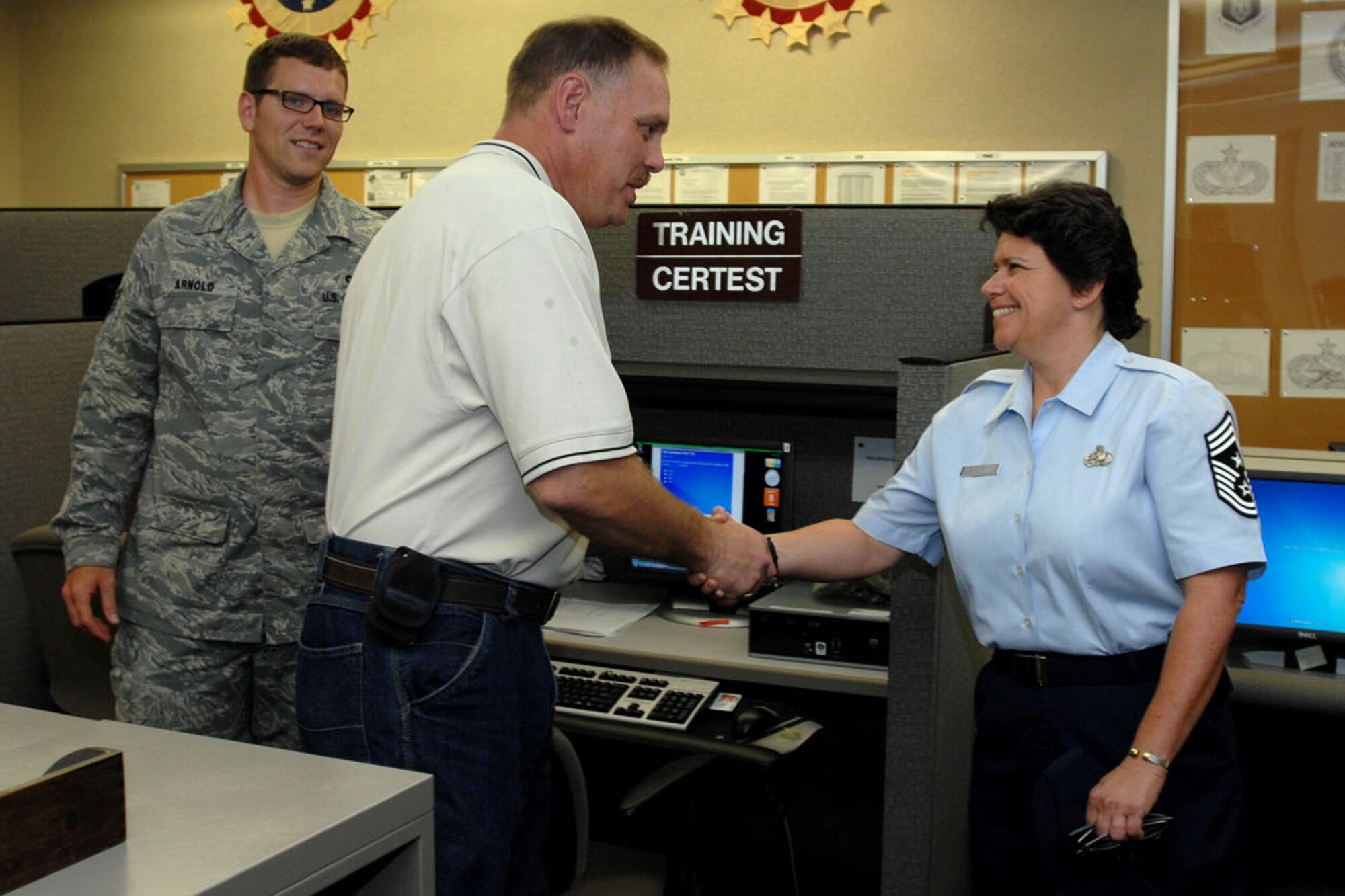 GRISSOM AIR RESERVE BASE, Ind. -- Chief Master Sgt. Karen Perkins shakes hands with Mr. John Somsel, 434th Civil Engineering Squadron construction engineer;  as she toured the Civil Engineering building  Aug. 8. Perkins recently became the new 434th Air Refueling wing command chief. Perkins visited the squadron in an effort to extend an open communication line to the staff there. Pictured left is Staff Sgt. Joshua Arnold, electrical systems specialist, 434th Civil Engineering Squadron. (U.S. Air Force photo/Senior Airman Jami K. Lancette)