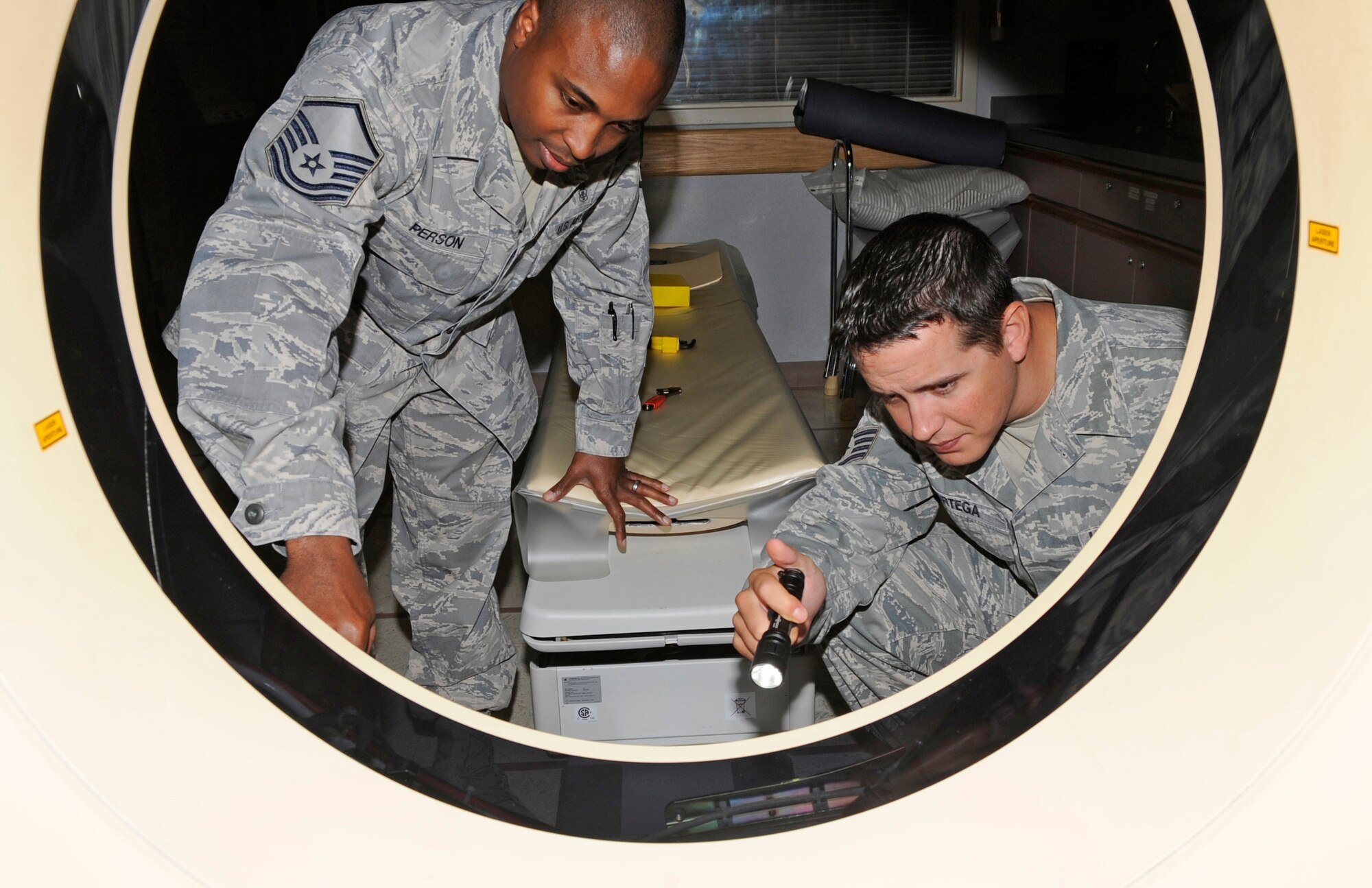 Master Sgt. Mark Person and Staff Sgt. Orlando Ortega, members of the 2nd Medical Group Medical Logistics Flight, inspect the inside of the computerized tomography scanner Aug. 22 as part of a routine inspection at the Medical Clinic on Barksdale Air Force Base, La. The team inspects all medical machines on base to make sure they are working correctly at all times. (U.S. Air Force photo/Airman 1st Class Andrea F. Liechti) (RELEASED)
