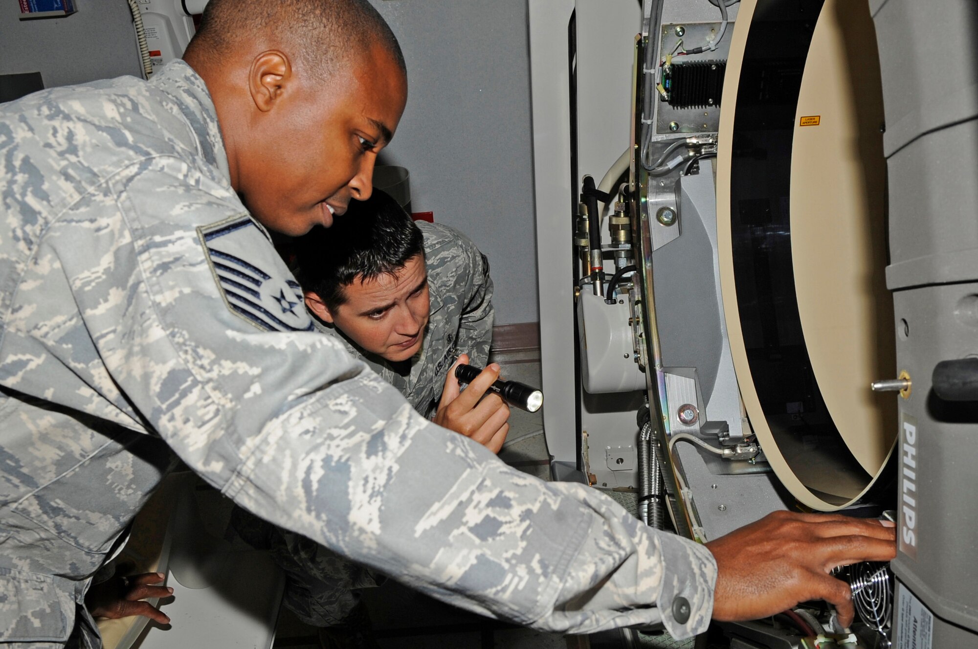 Master Sgt. Mark Person and Staff Sgt. Orlando Ortega, members of the 2nd Medical Group Medical Logistics Flight, inspect the inside of the computerized tomography scanner Aug. 22 as part of a routine inspection at the Medical Clinic on Barksdale Air Force Base, La. The team ensures the machine is inspected at least once every six months. (U.S. Air Force photo/Airman 1st Class Andrea F. Liechti) (RELEASED)