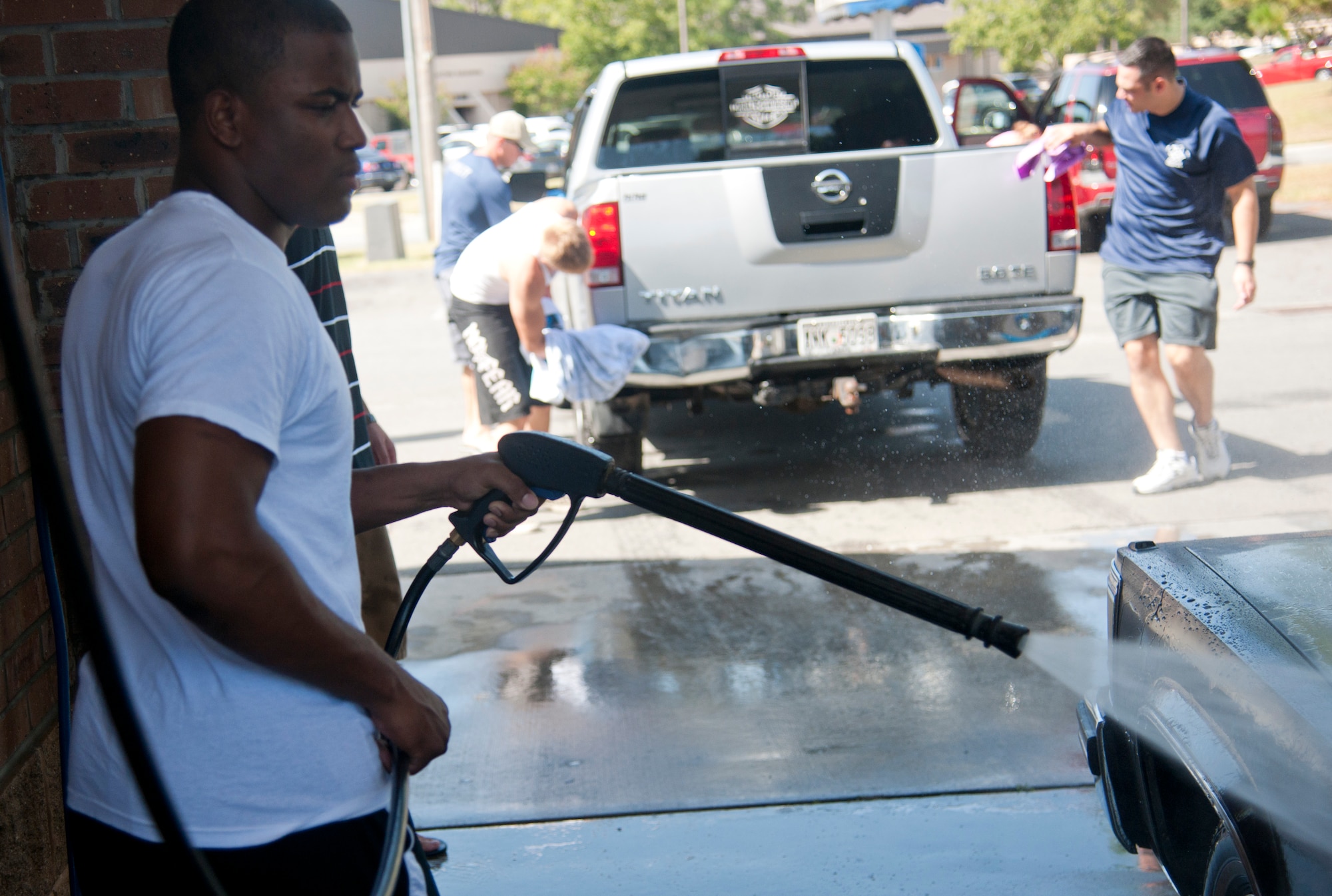 U.S. Air Force Airman 1st Class Derrick Allen, active member of the Airmen Committed to Excellence committee, hoses down a car during the first sergeant’s car wash on Moody Air Force Base, Ga., Aug. 26, 2011. The committee raised $224 to go towards future ACE-sponsored events. (U.S. Air Force photo by Airman 1st Class Paul Francis/Released)

