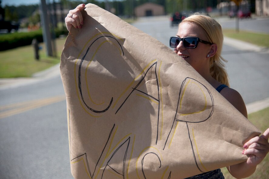 U.S. Air Force Airman 1st Class Lindy Pata, Airmen Committed to Excellence committee president, attracts customers by holding a car wash sign on Moody Air Force Base, Ga., Aug. 26, 2011. The ACE committee has organized many events such as a pool party to help boost morale of Airmen on Moody. (U.S. Air Force photo by Airman 1st Class Paul Francis/Released)