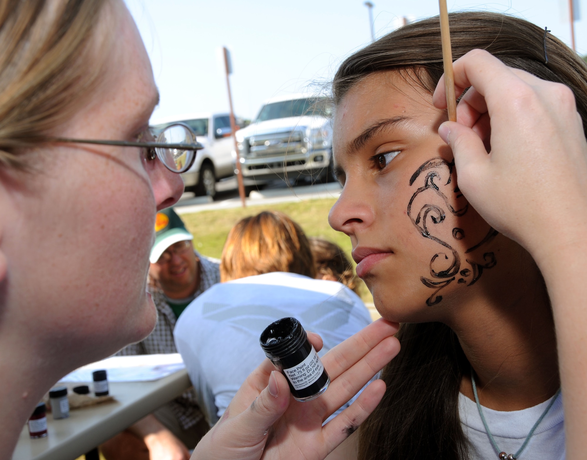 Megan Barton, left, 81st Force Support Squadron, paints a design on the face of Karissa McAnelly, 13, at the Keesler 70th Birthday Celebration at Bay Breeze Event Center Aug. 27.  Karissa's parents are Master Sgt. James and Velkys McAnelly, 334th Training Squadron.  (U.S. Air Force photo by Kemberly Groue)