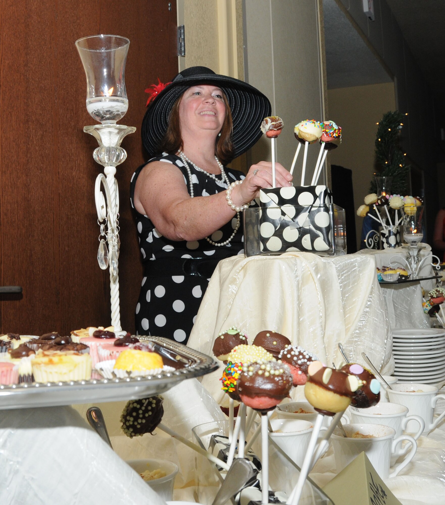 Peggy Fairley, 81st Force Support Squadron, replenishes the pastry table with cake pops and other treats during the Keesler 70th Birthday Celebration at Bay Breeze Event Center Aug. 27.  (U.S. Air Force photo by Kemberly Groue)