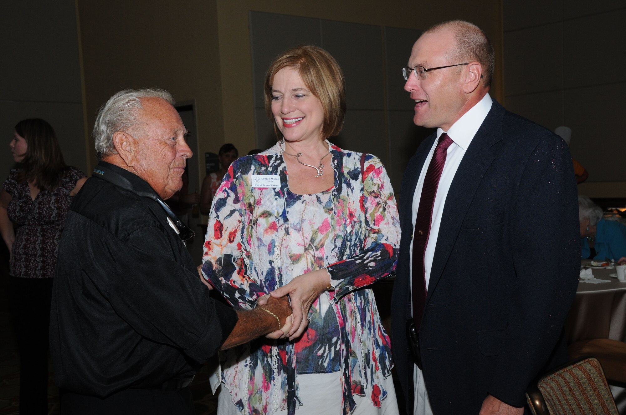 From left, Dick Wilson, Biloxi Chamber of Commerce and Mississippi Coast Military Officers Association member; Ocean Springs Mayor Connie Moran and Brig. Gen. Andrew Mueller, 81st Training Wing commander, chat during the Keesler 70th Birthday Celebration at Bay Breeze Event Center Aug. 27.  (U.S. Air Force photo by Kemberly Groue)
