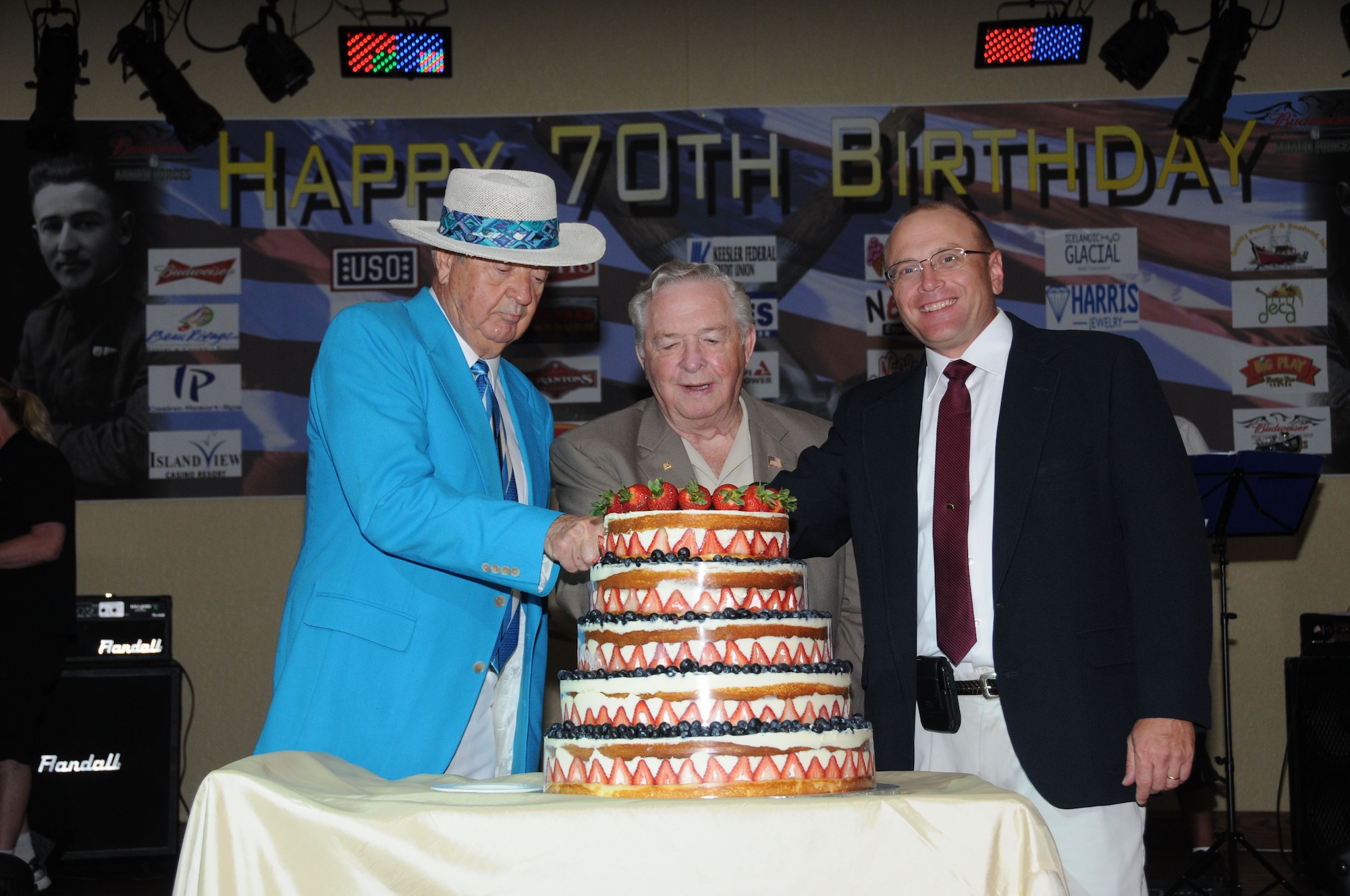 Dean Todd, left, and Don McCormick, members of the Keesler Federal Credit Union Board of Directors, assist Brig. Gen. Andrew Mueller, 81st Training Wing commander, with cutting the cake during the Keesler 70th Birthday Celebration at Bay Breeze Event Center Aug. 27.   (U.S. Air Force photo by Kemberly Groue)