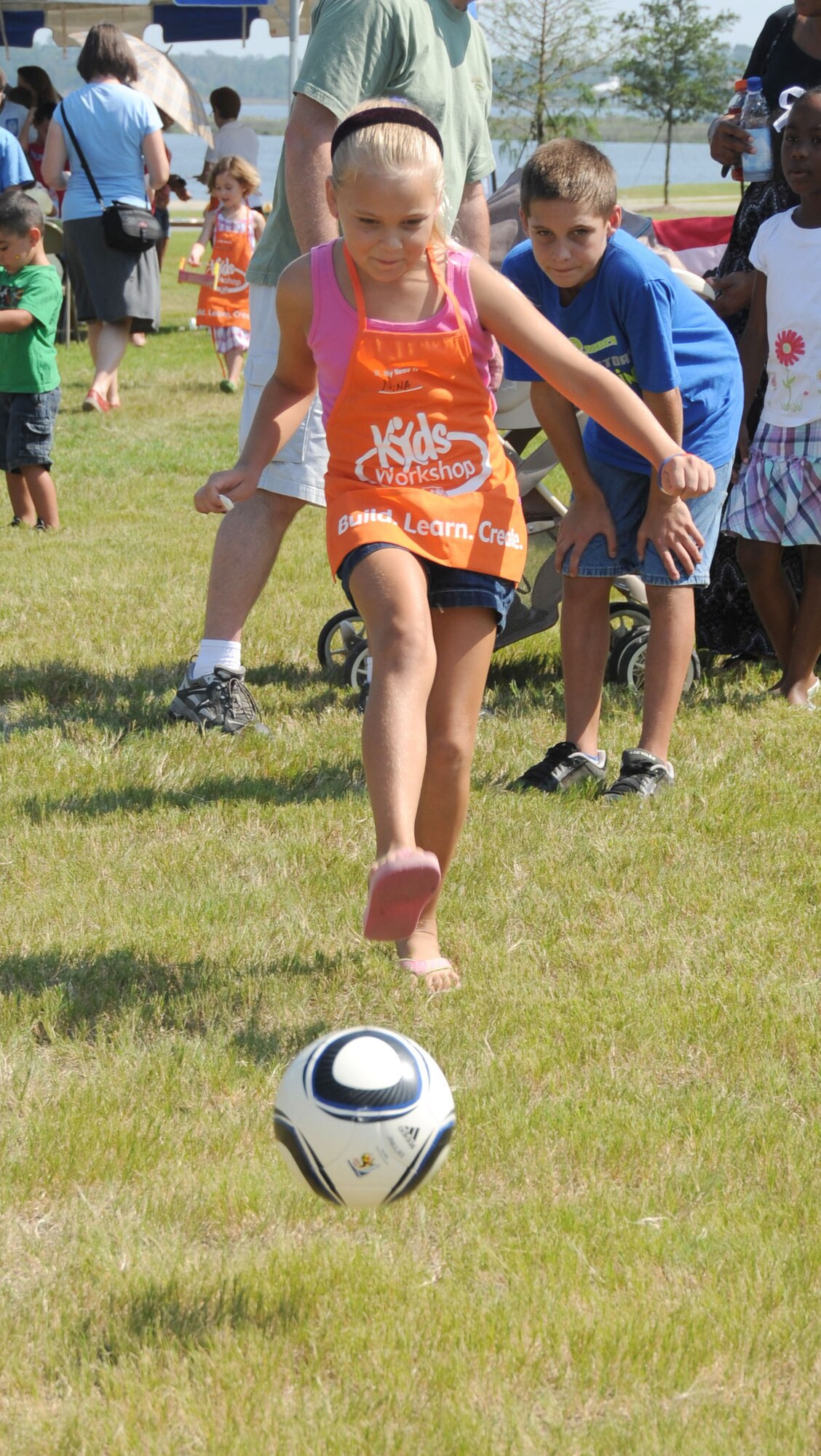 Nina Gestring, 8, kicks a soccer ball towards the target while her older brother Nicholas, 11, keeps an eye on it during the Keesler 70th Birthday Celebration at Bay Breeze Event Center Aug 27. The children's parents are Master Sgt. Ken and Corina Gestring, 81st Surgical Operations Squadron.  (U.S. Air Force photo by Kemberly Groue)
