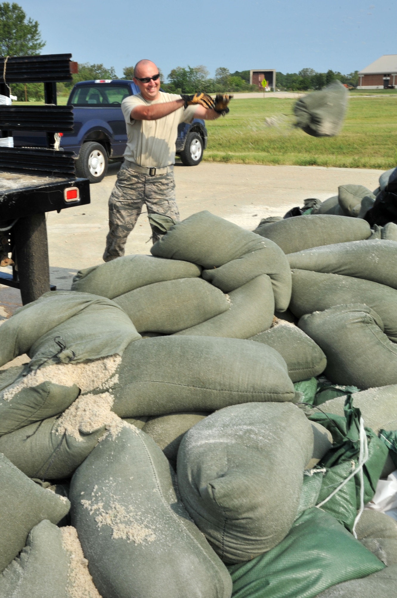 U.S. Air Force Airman 1st Class Steven Boyle, 633rd Civil Engineer Squadron water and fuels maintainer, recovers sandbags following Hurricane Irene at Langley Air Force Base, Va., Aug. 29, 2011. Members from across Langley AFB went to work cleaning and recovering the base on Sunday when the storm passed and will continue clean-up operations until the base has been completely restored. (U.S. Air Force photo by Airman 1st Class Camilla Griffin/Released)