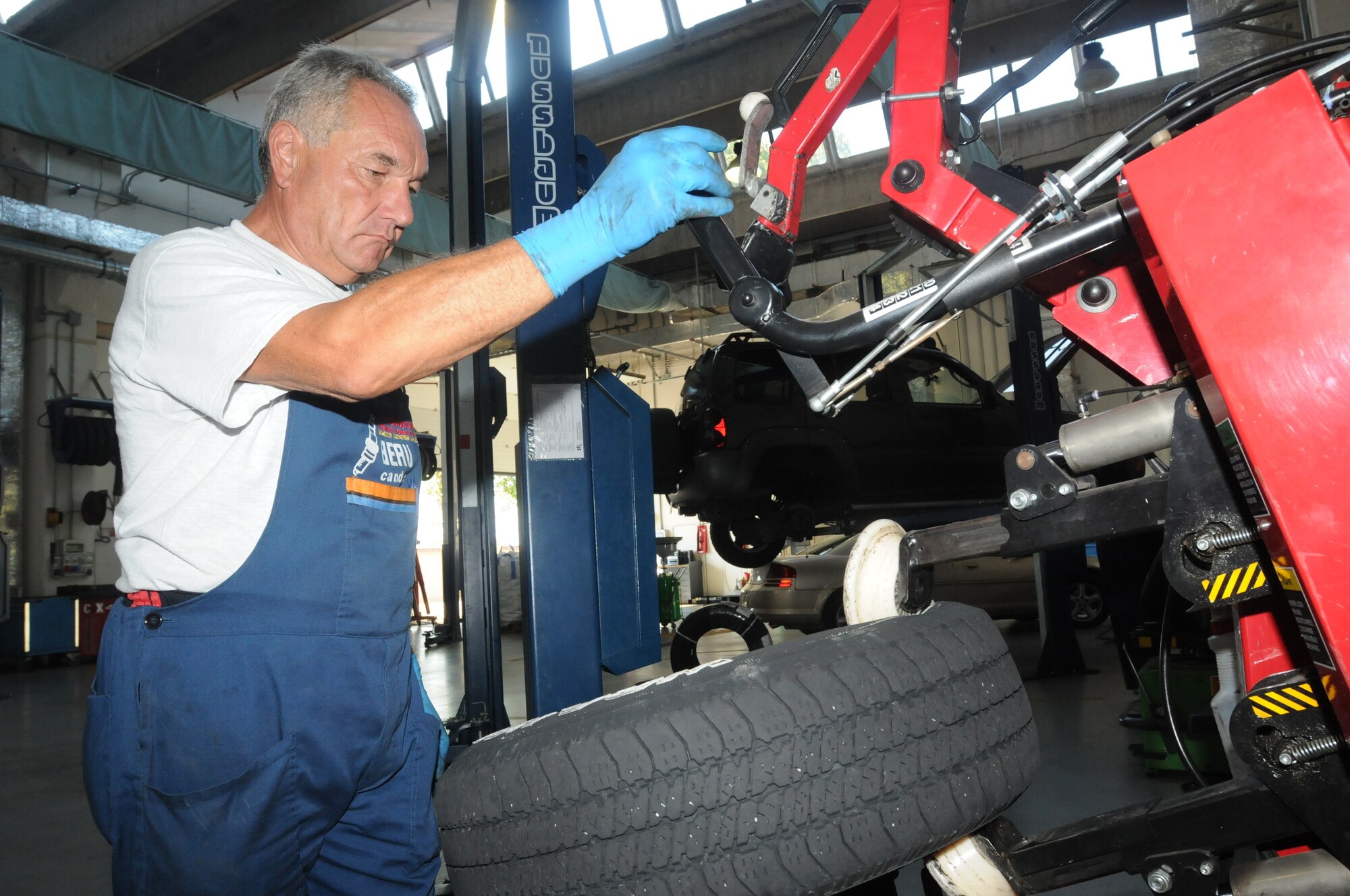 Valter Cancian, 31st Force Support Squadron Auto Hobby Shop mechanic, uses a tire changer to remove a tire for a wheel Aug. 18 at Aviano Air Base, Italy. The tire changer is use to remove a tire from one wheel and place it onto another. The Auto Hobby provides automotive repairs and diagnosis with lifts, stall spaces, specialized equipment, do-it-yourself workspace and certified staff to assist with all vehicle maintenance needs. (U.S. Air Force photo/Airman LaVel Sterling)