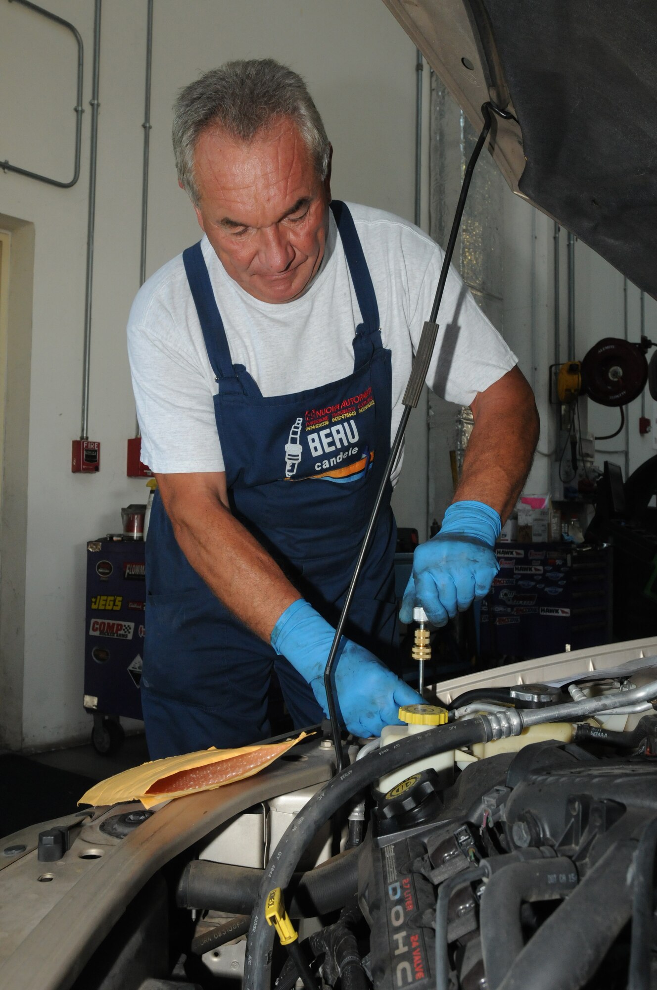 Valter Cancian 31st Force Support Squadron Auto Hobby Shop mechanic, services a vehicle?s air conditioning unit Aug. 18 at Aviano Air Base, Italy. Some of the services the Auto Hobby Shop offer include oil changes, tune-ups, brake service and safety checks. (U.S. Air Force photo/Airman LaVel Sterling)