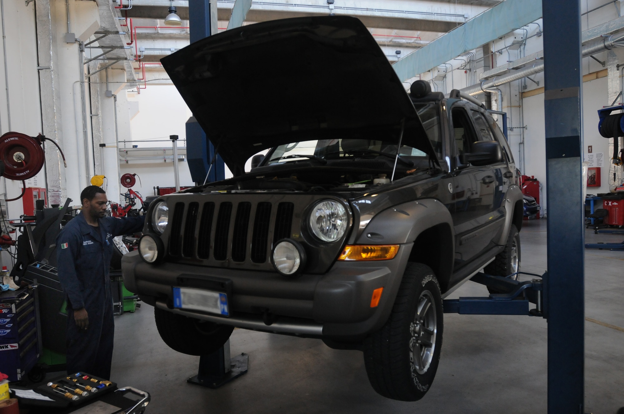 Mike Jones, 31st Force Support Squadron Auto Hobby Shop manager, uses a lift to elevate a sport utility vehicle Aug. 18 at Aviano Air Base, Italy. Jones uses the vehicle lift to have better access to the under carriage. (U.S. Air Force photo/Airman LaVel Sterling)